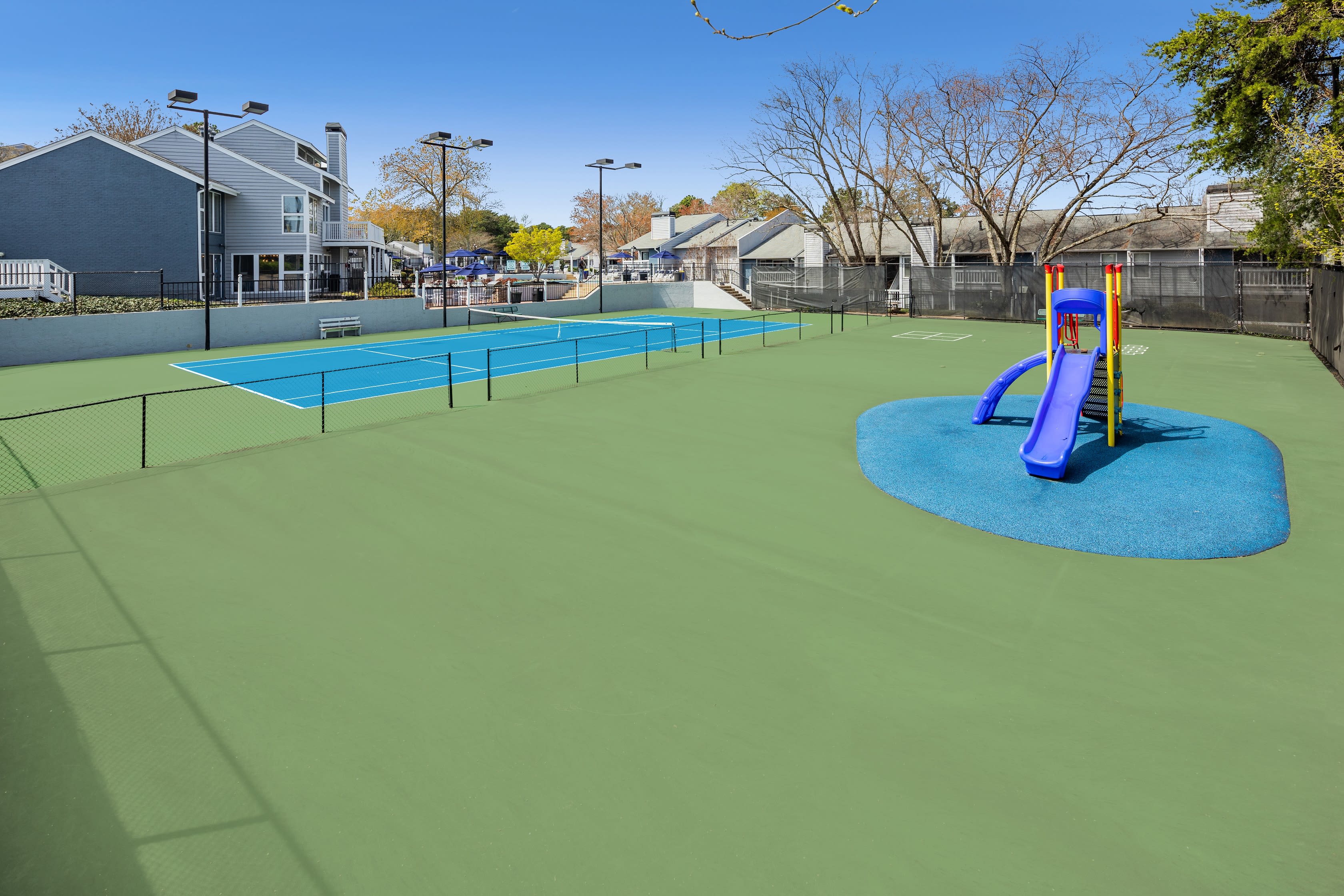 Outdoor tennis court and a slide for children at The Everette at East Cobb in Marietta, Georgia