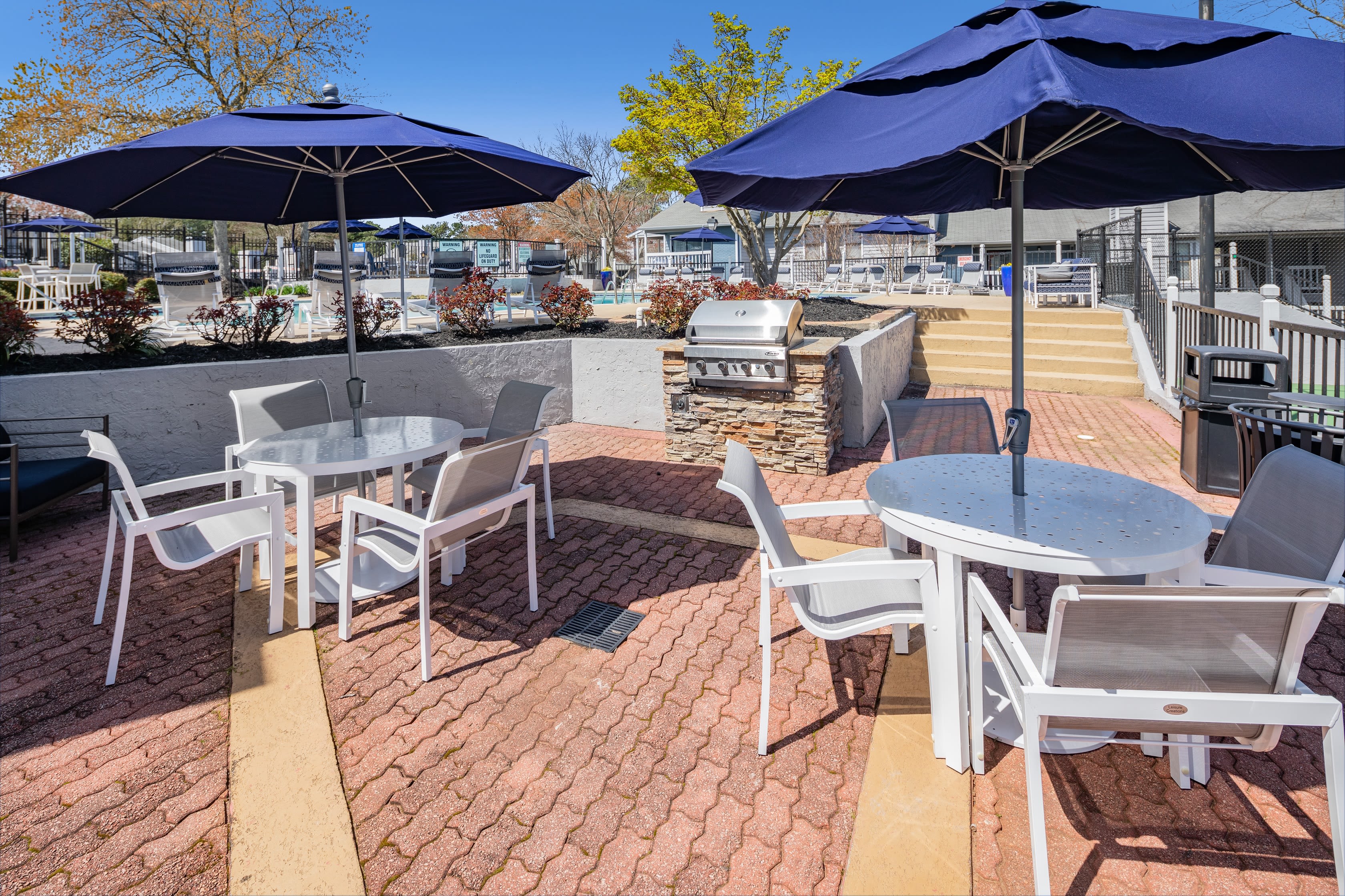 Tables with chairs and umbrellas for outdoor seating The Everette at East Cobb in Marietta, Georgia