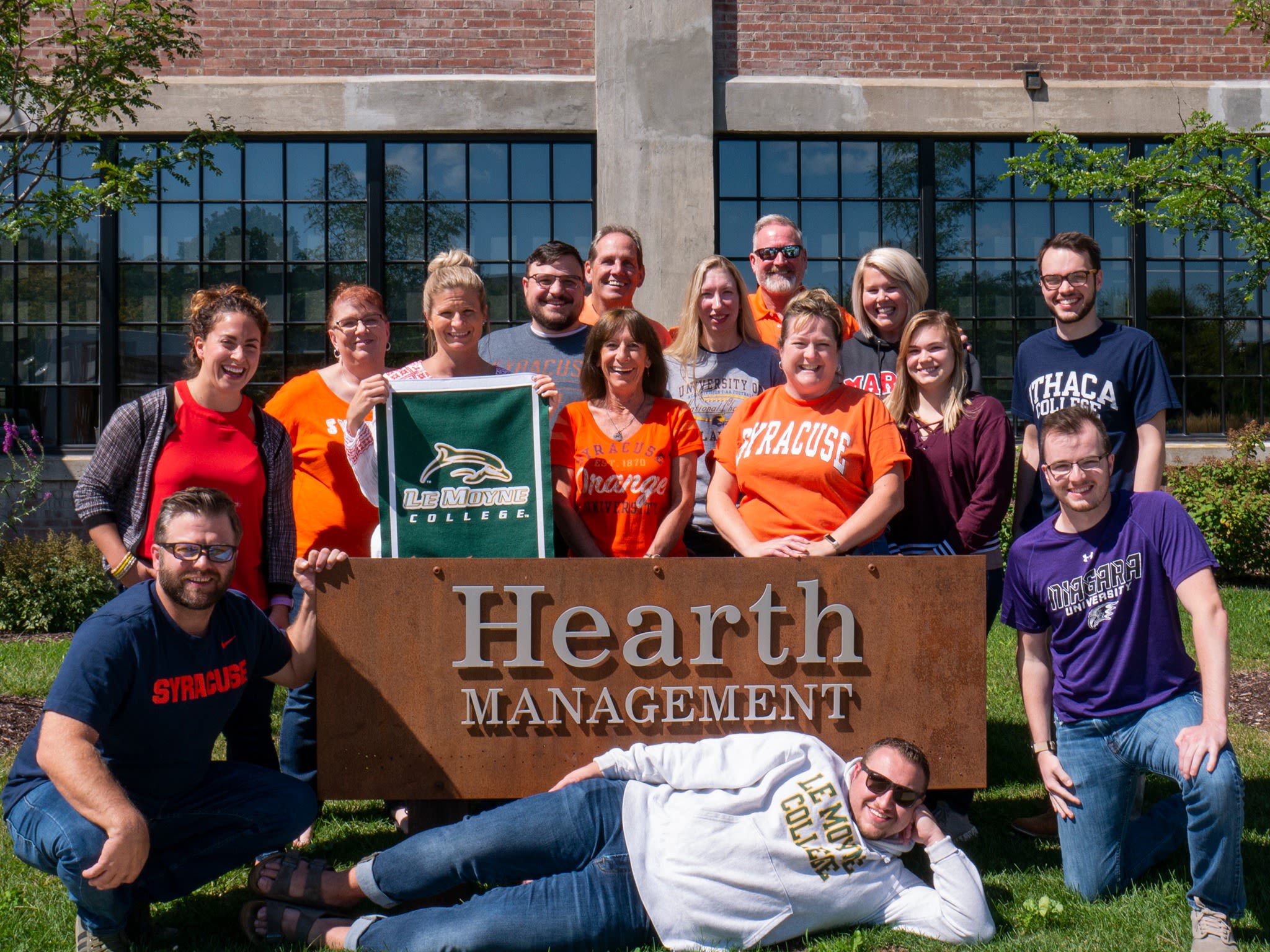 Hearth Management team members in front of our sign