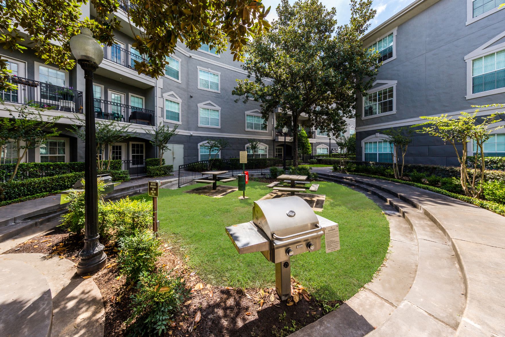 Grill near lawn with picnic tables at Marquis at Tanglewood in Houston, Texas