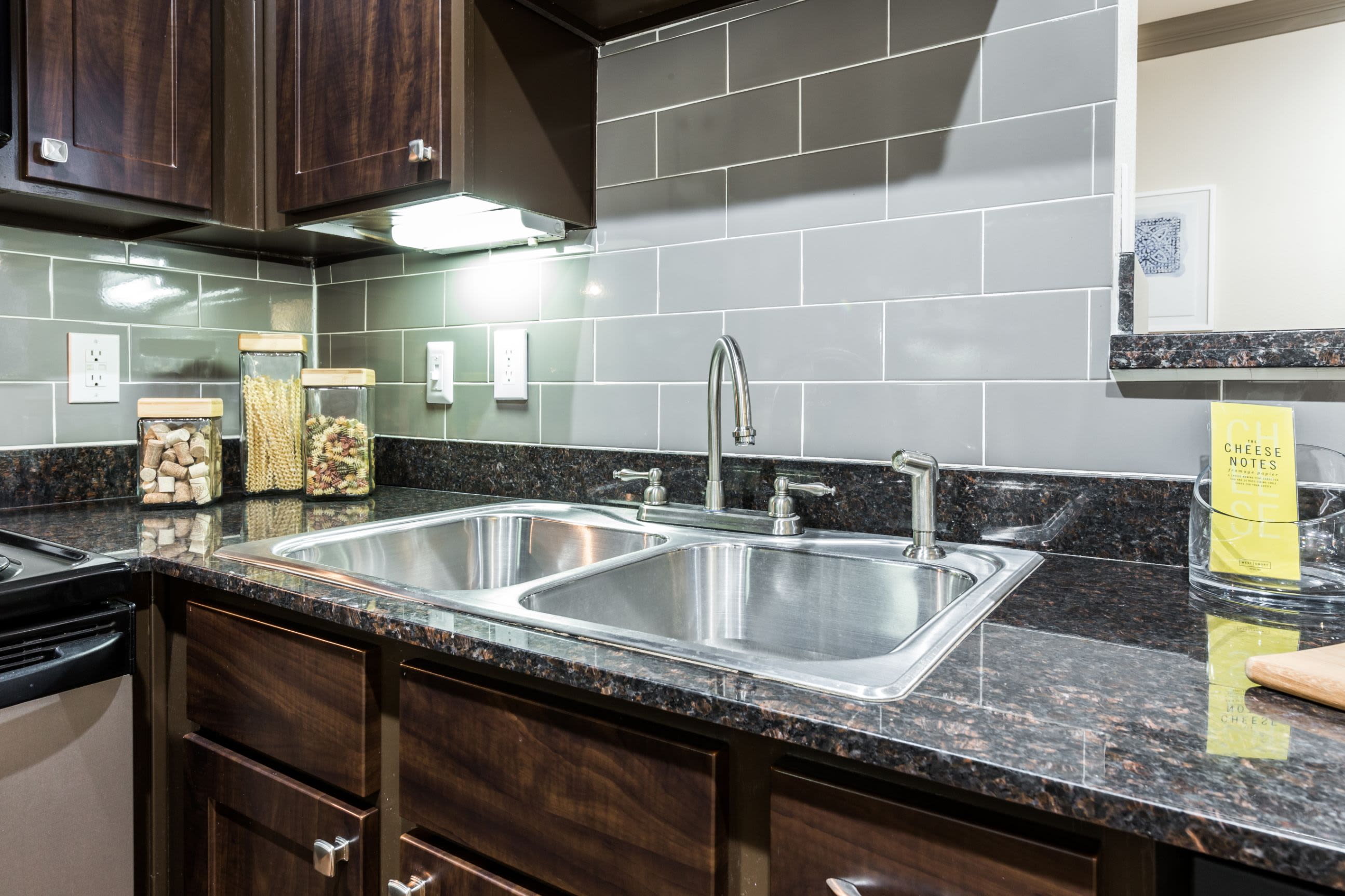 Kitchen with black countertops at Marquis at Tanglewood in Houston, Texas