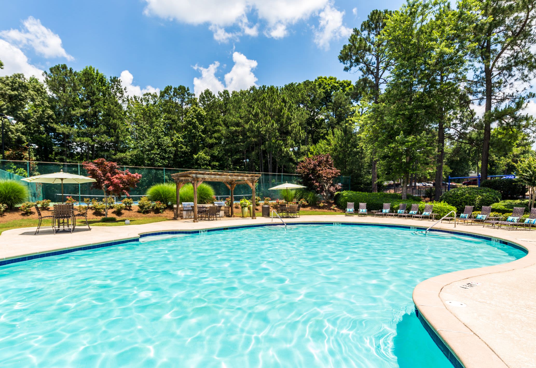 Swimming pool surrounded by trees at Marquis at Perimeter Center in Atlanta, Georgia