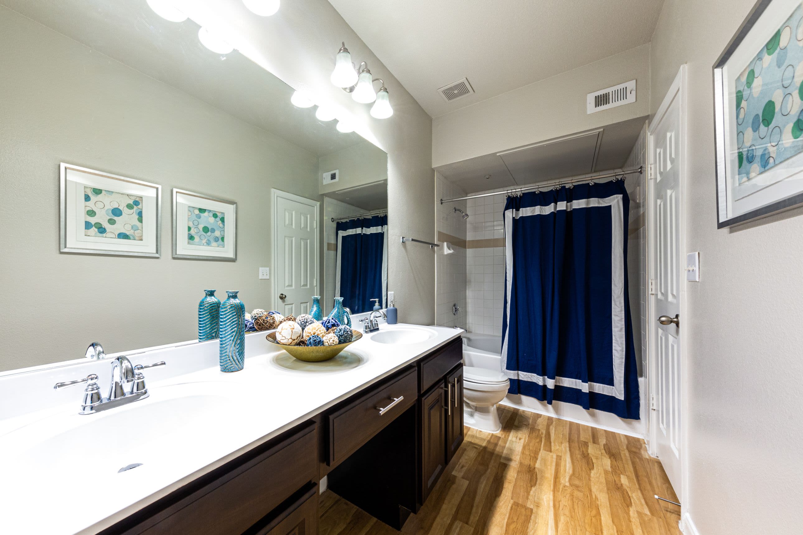 Bathroom with dark cabinets and white counters at Marquis at Westchase in Houston, Texas