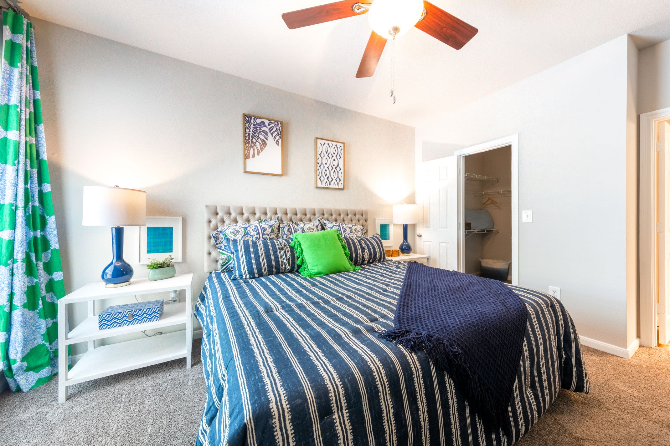 Bedroom with large bed and ceiling fan at Marquis at Westchase in Houston, Texas