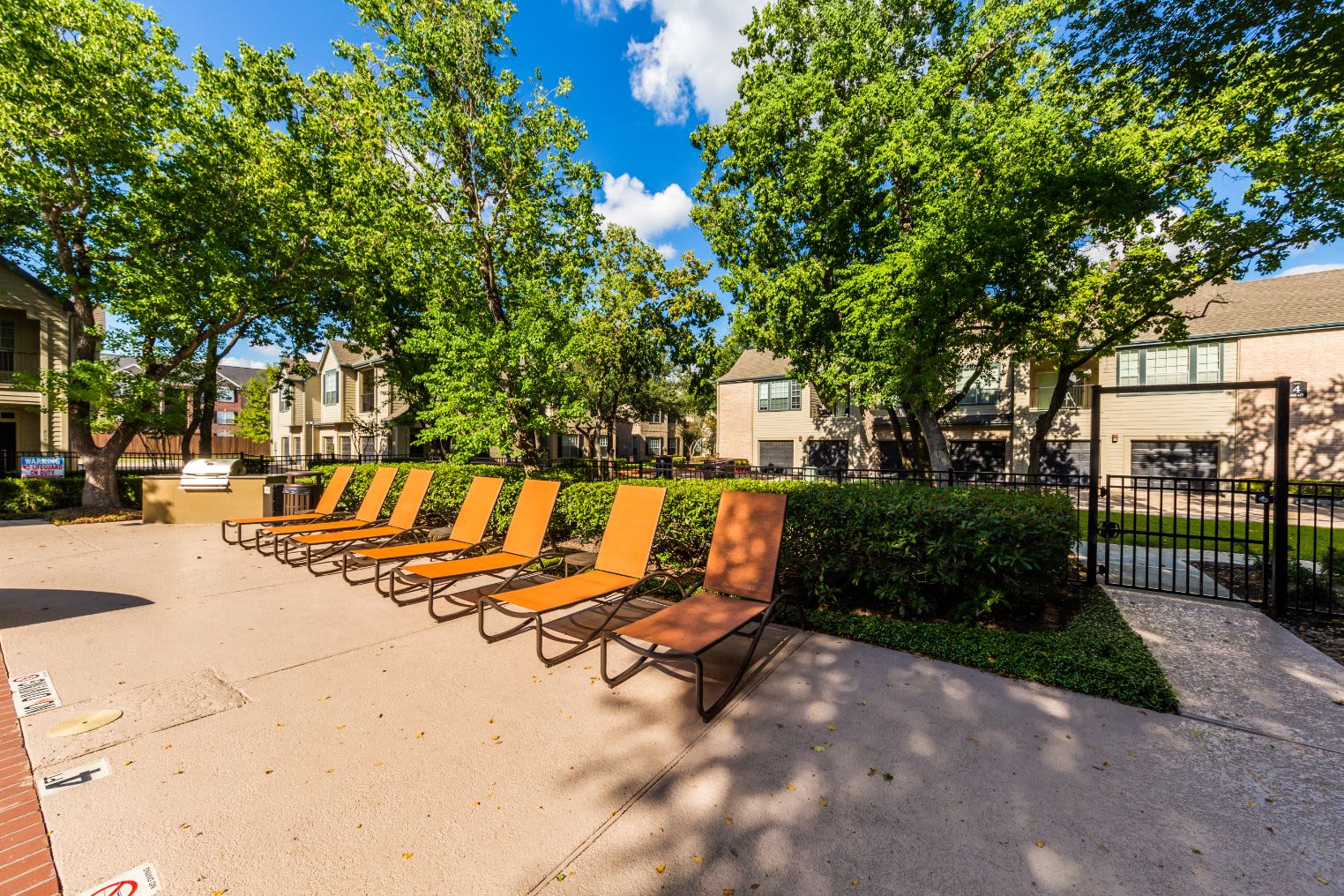 Sun chairs next to pool at Marquis at Westchase in Houston, Texas