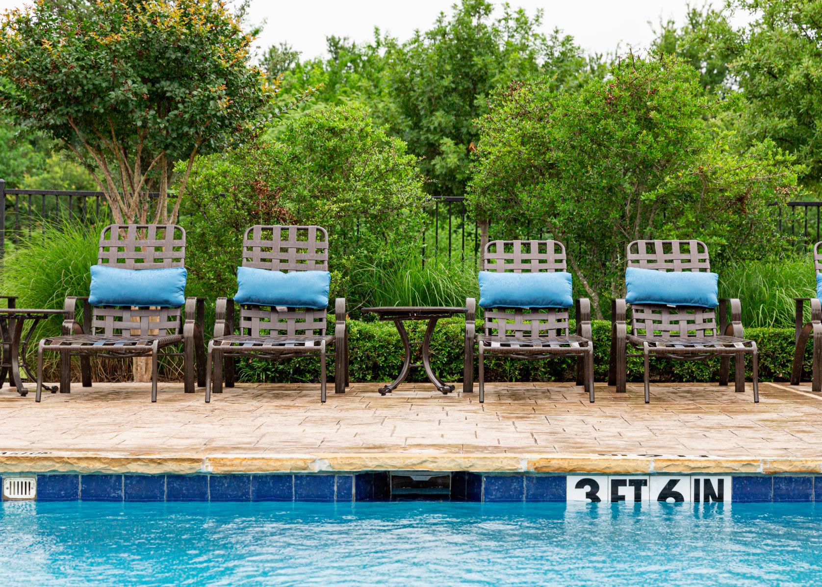 Community pool with sun chairs at Marquis Rockwall in Rockwall, Texas