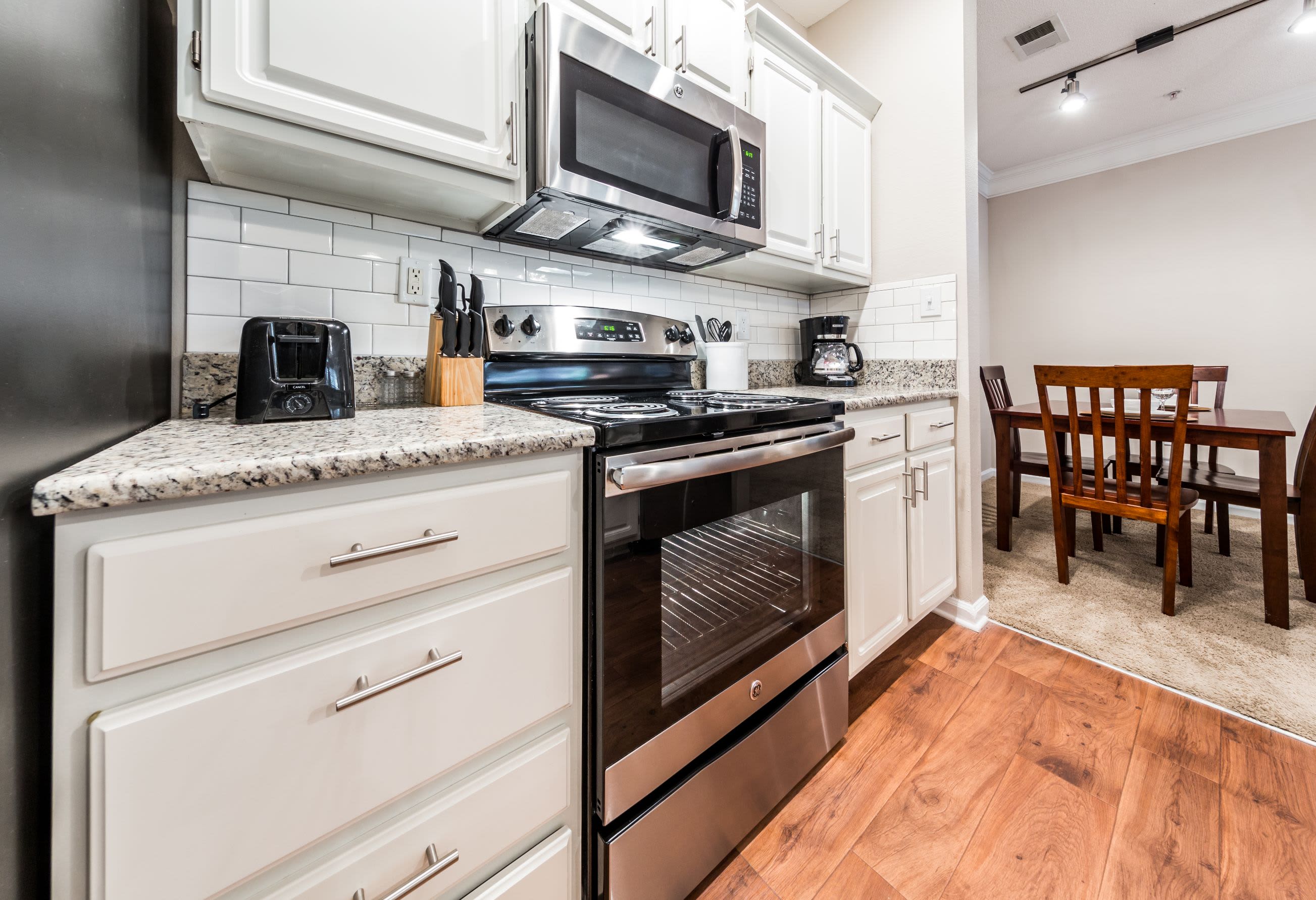 Modern kitchen with wood style floors at The Preserve at Ballantyne Commons in Charlotte, North Carolina