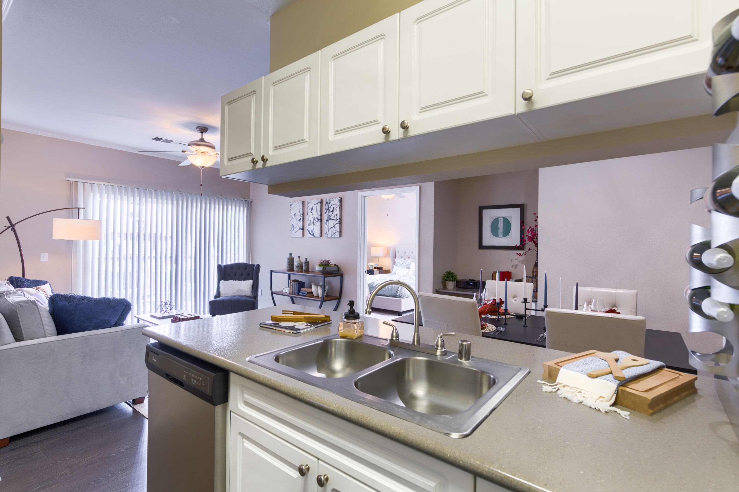 Modern kitchen adjacent to living area at Whisper Creek Apartment Homes in Lakewood, Colorado
