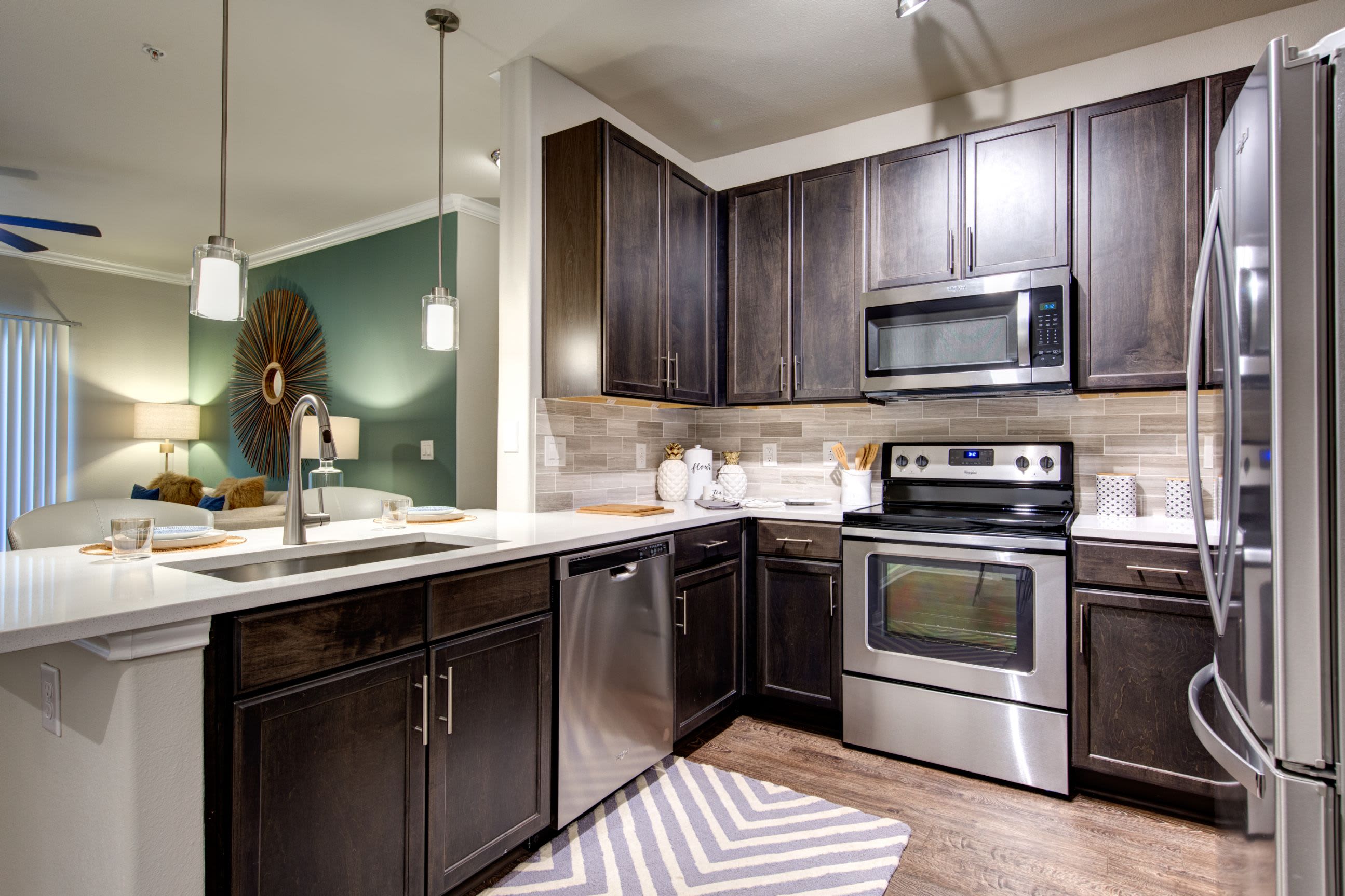 Modern kitchen with wood style floors at Marquis at The Woodlands in Spring, Texas