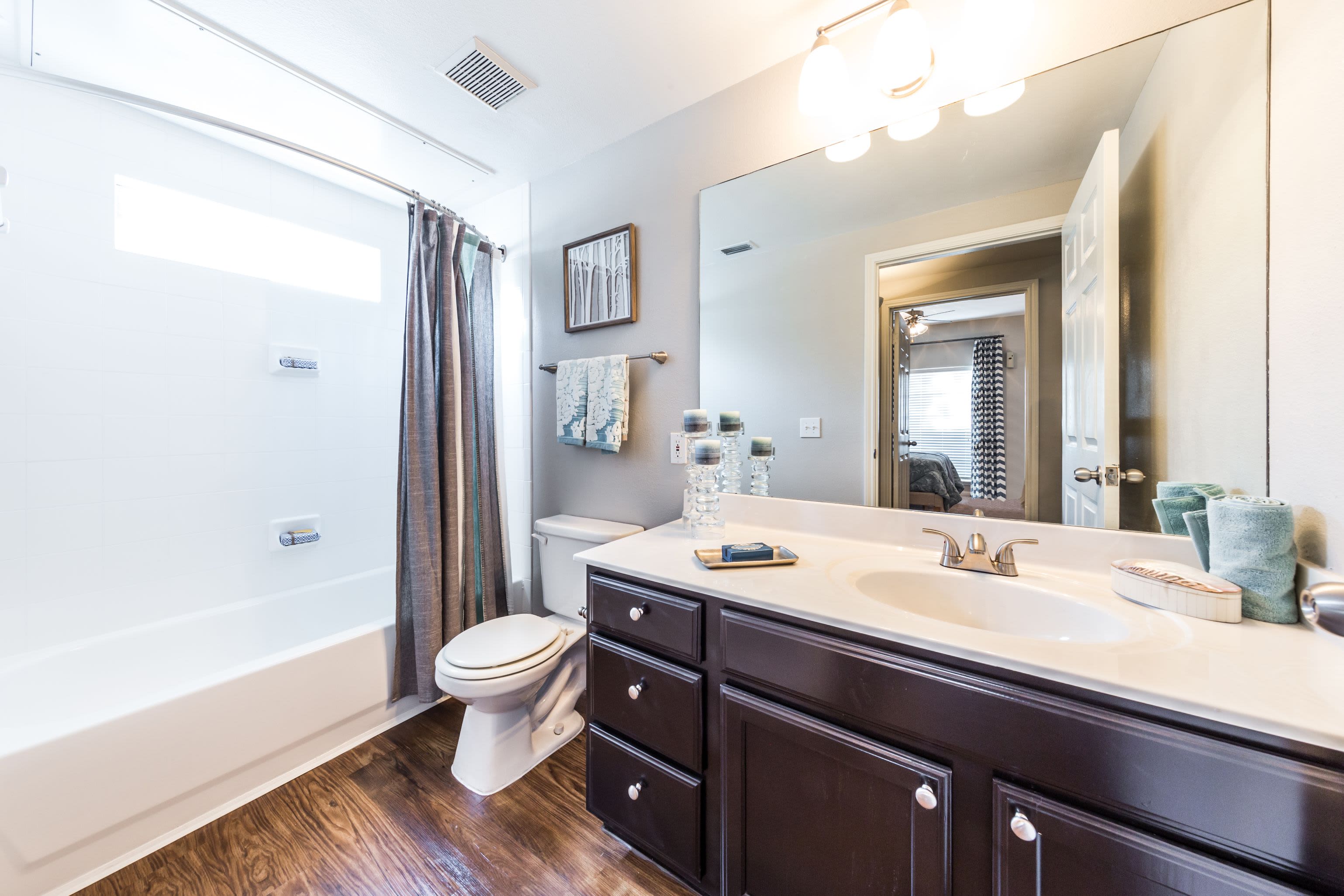 Bathroom with dark cabinets and white countertops at Marquis on Westheimer in Houston, Texas