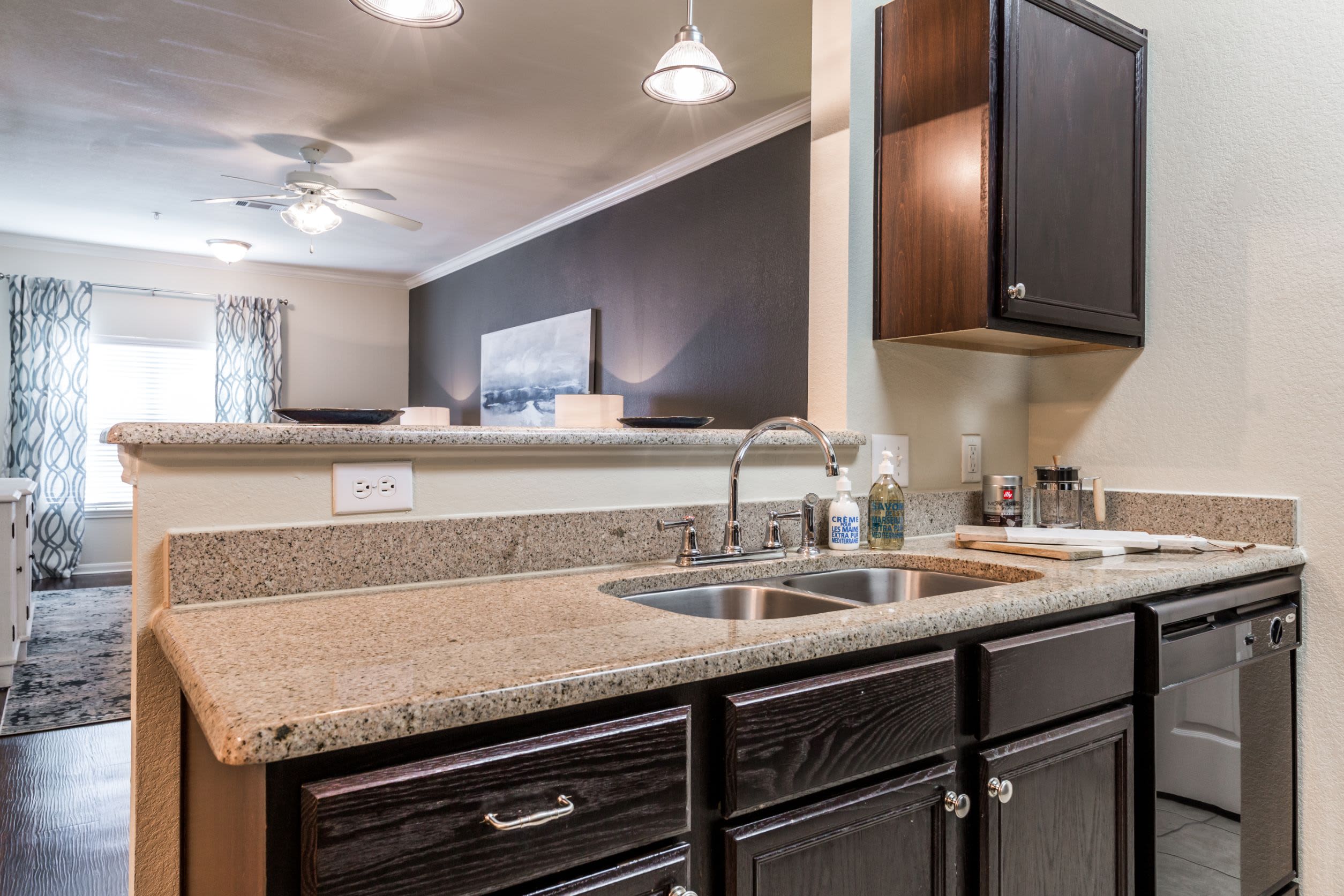 Kitchen with dark colored cabinets at Marquis at The RIM in San Antonio, Texas