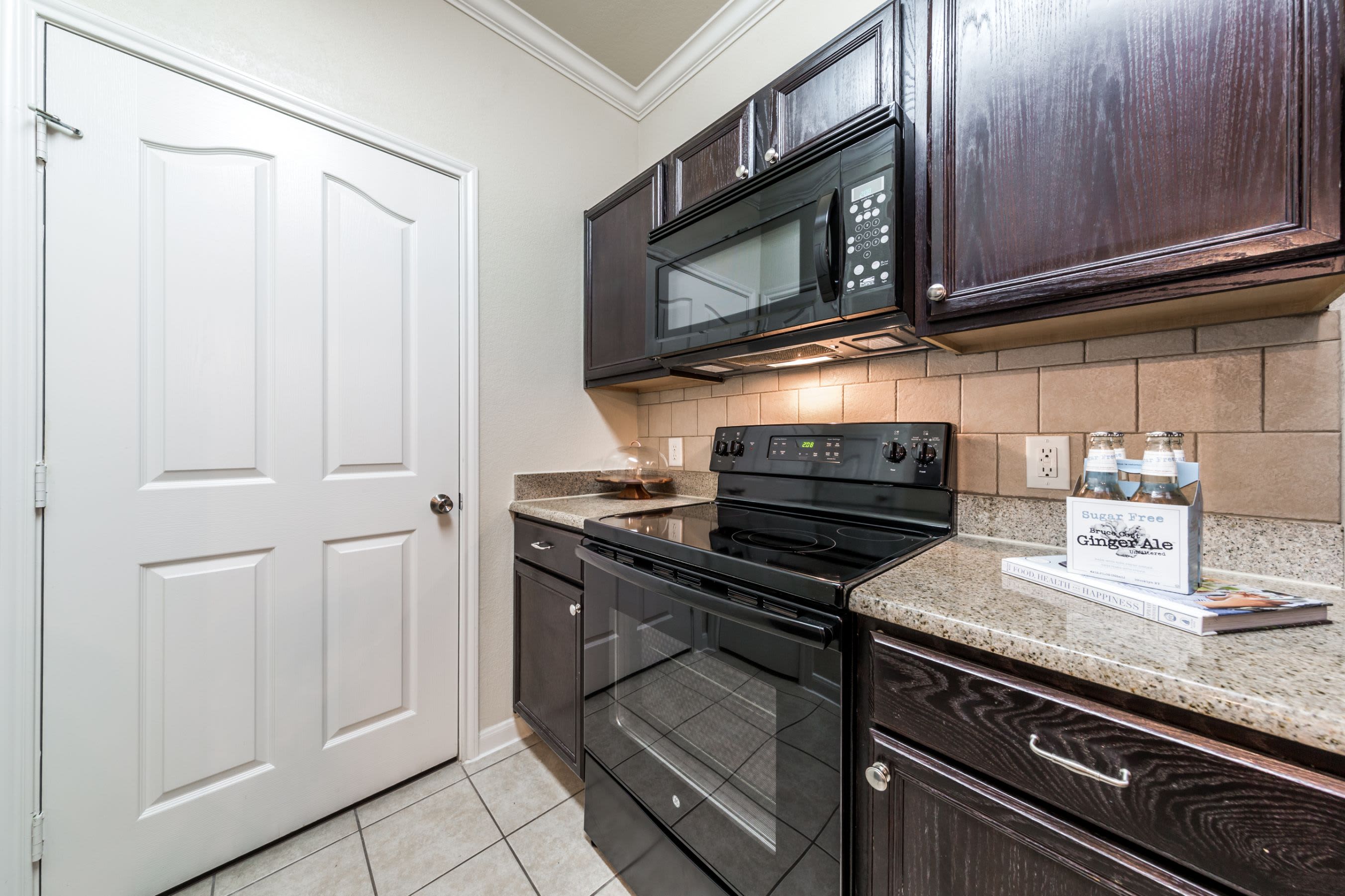Kitchen with black appliances at Marquis at The RIM in San Antonio, Texas