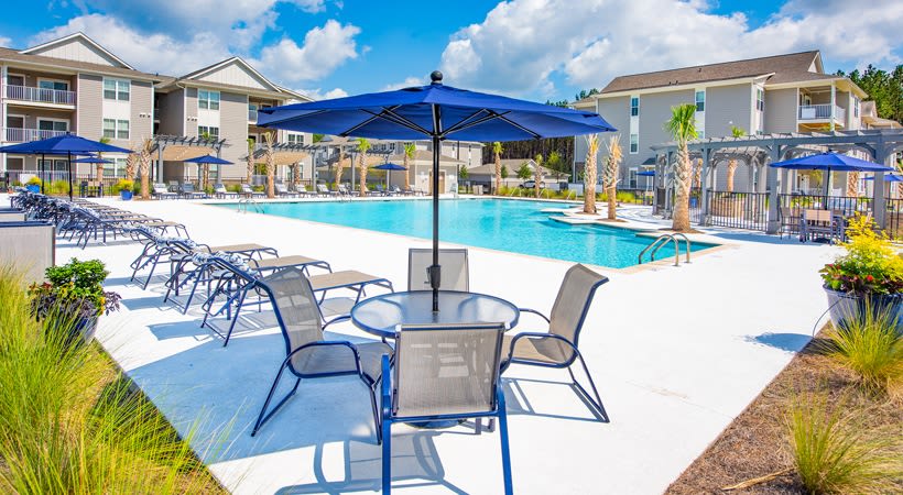 Outdoor grilling area with seating and places to cook poolside at The Isaac in Summerville, South Carolina