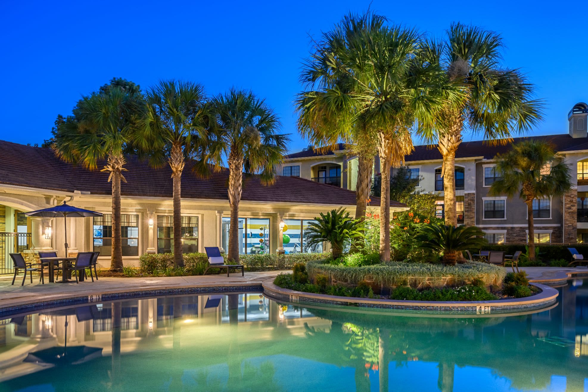 Lighted pool at sunset with palm trees at Marquis Lakeline Station in Austin, Texas