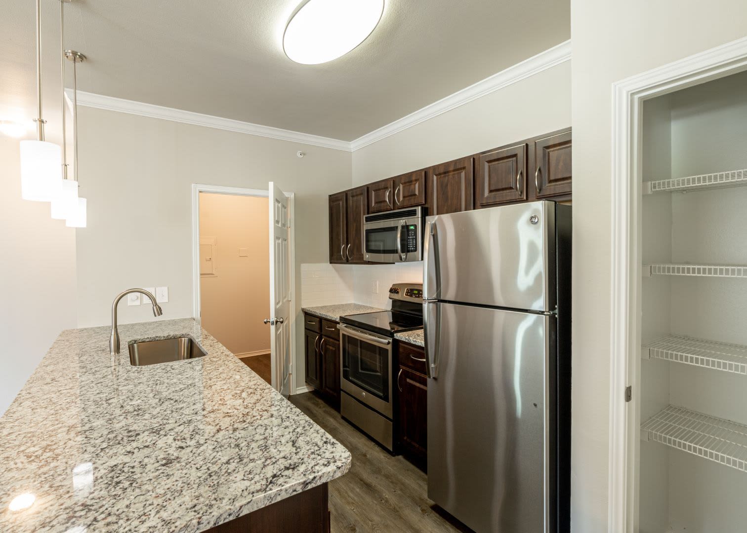 Modern kitchen with granite style countertops at Marquis at Stonebriar in Frisco, Texas