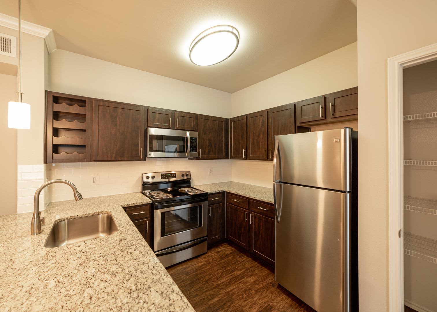 Bright kitchen with wood style floors at Marquis at Stonebriar in Frisco, Texas