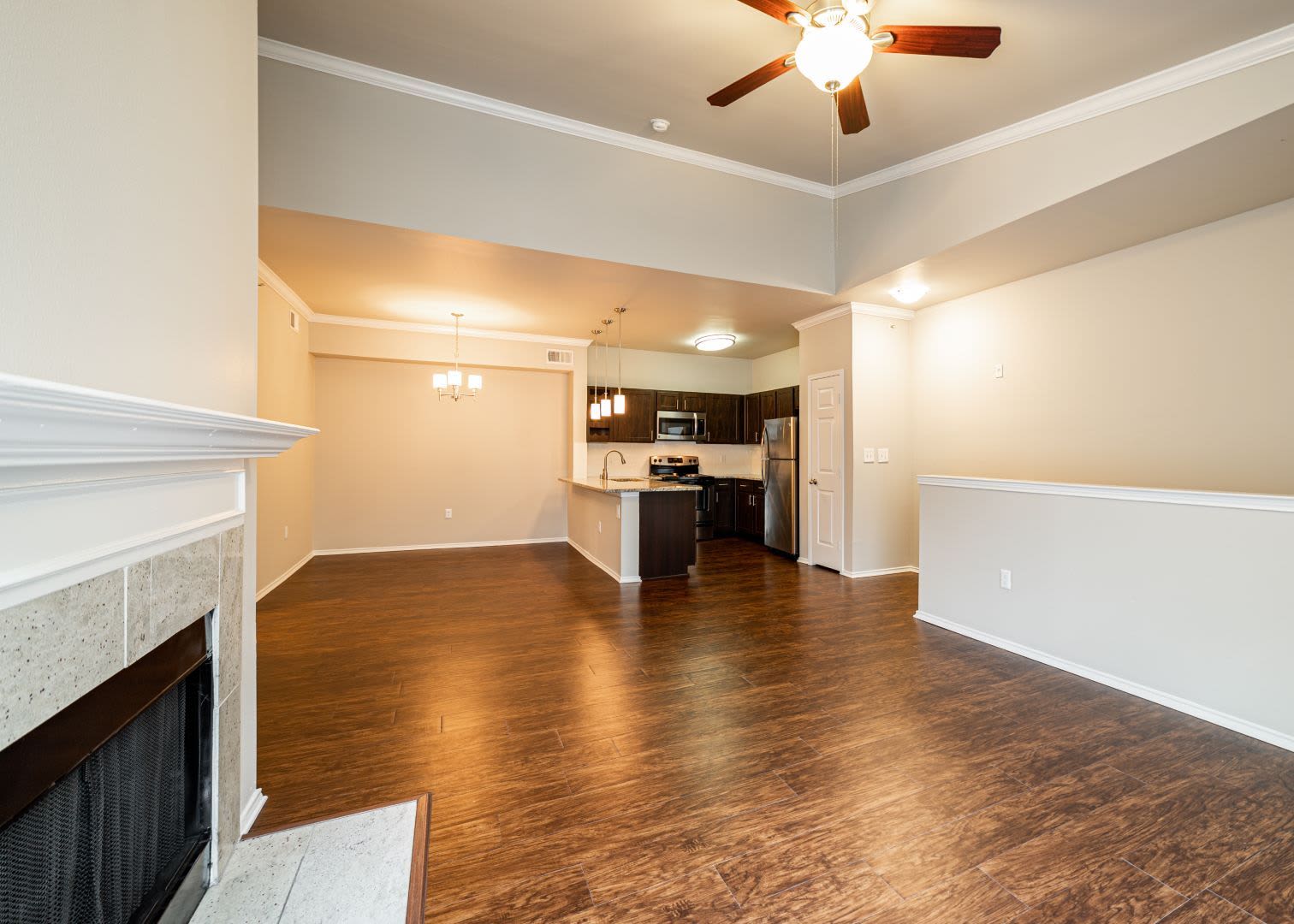 Open living room and dining area with wood style floors at Marquis at Stonebriar in Frisco, Texas