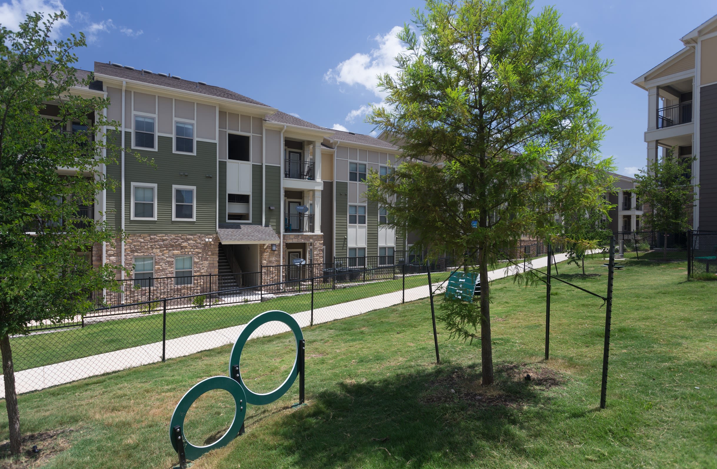 Sprawling green lawn and trees outside Encore 281 in San Antonio, Texas
