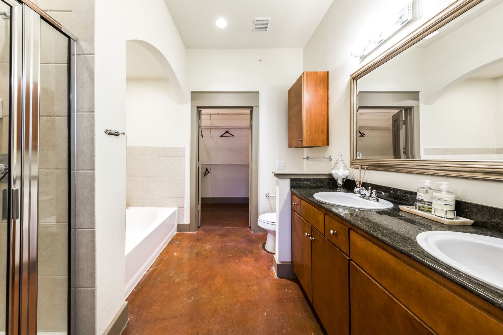 Large bathroom with an attached closet at Marquis Lofts on Sabine in Houston, Texas