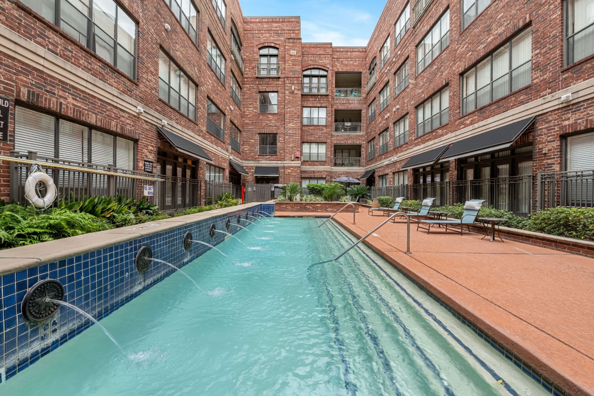 Sparkling pool with a water feature at Marquis Lofts on Sabine in Houston, Texas