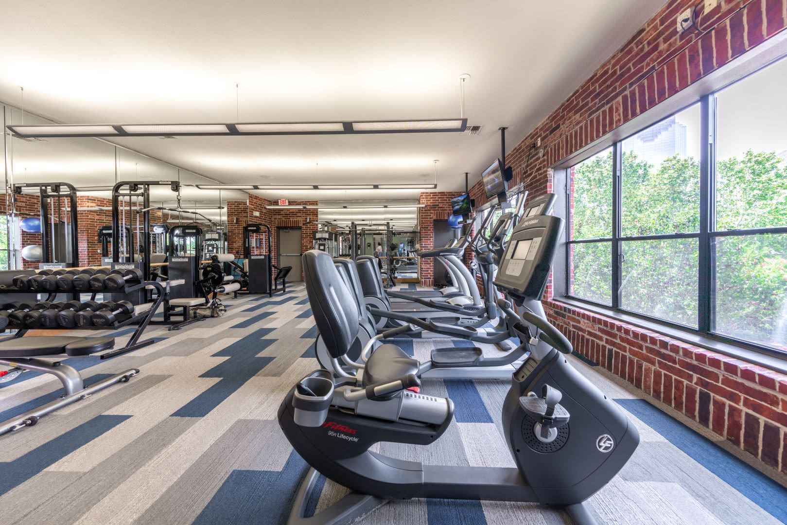 Cardio and weight machines in fitness center at Marquis Lofts on Sabine in Houston, Texas