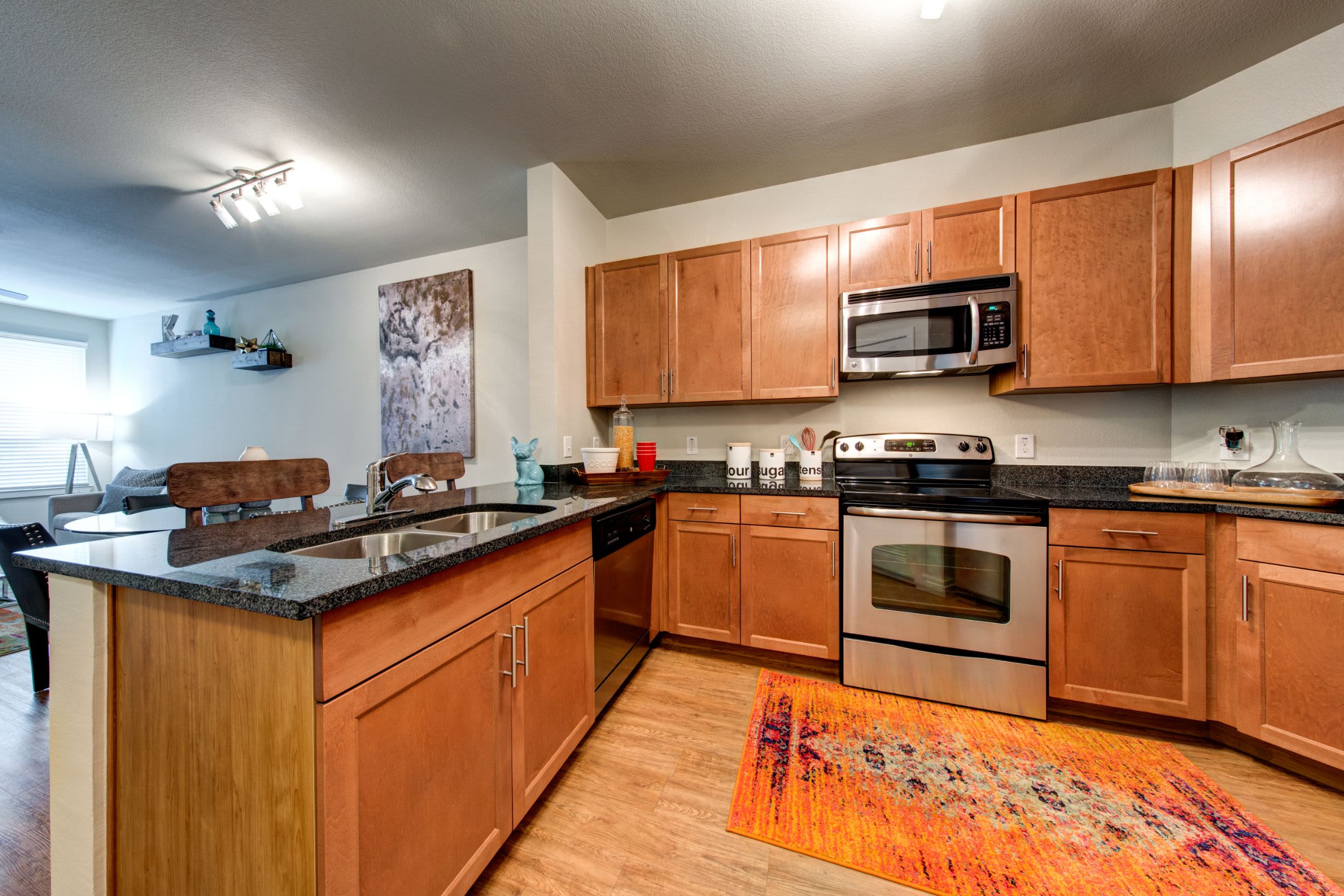 Kitchen with modern appliances and wood floors at The Marq on West 7th in Fort Worth, Texas