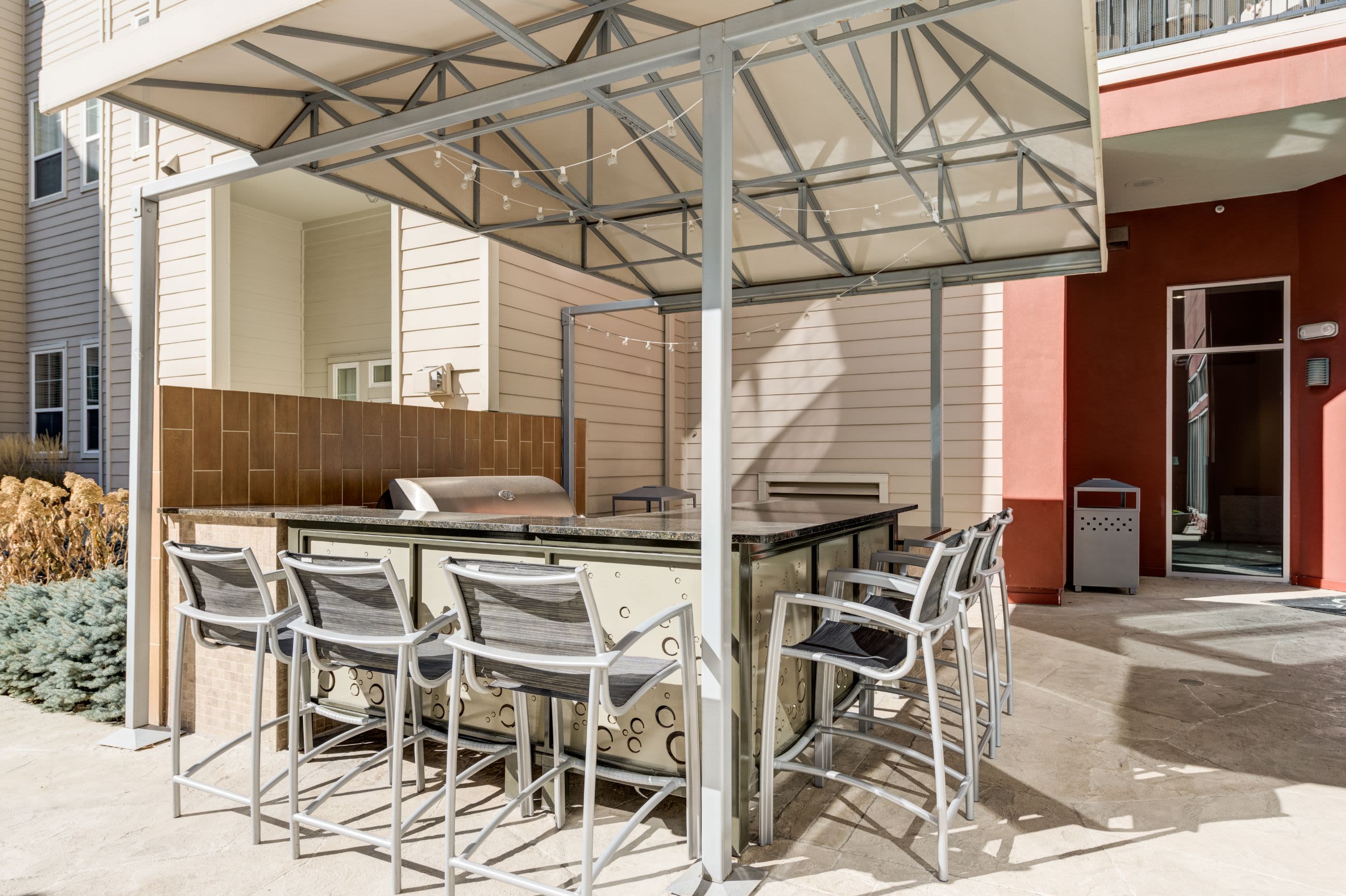 Outdoor kitchen with a grill and a breakfast bar at The Marq at Ridgegate in Lone Tree, Colorado