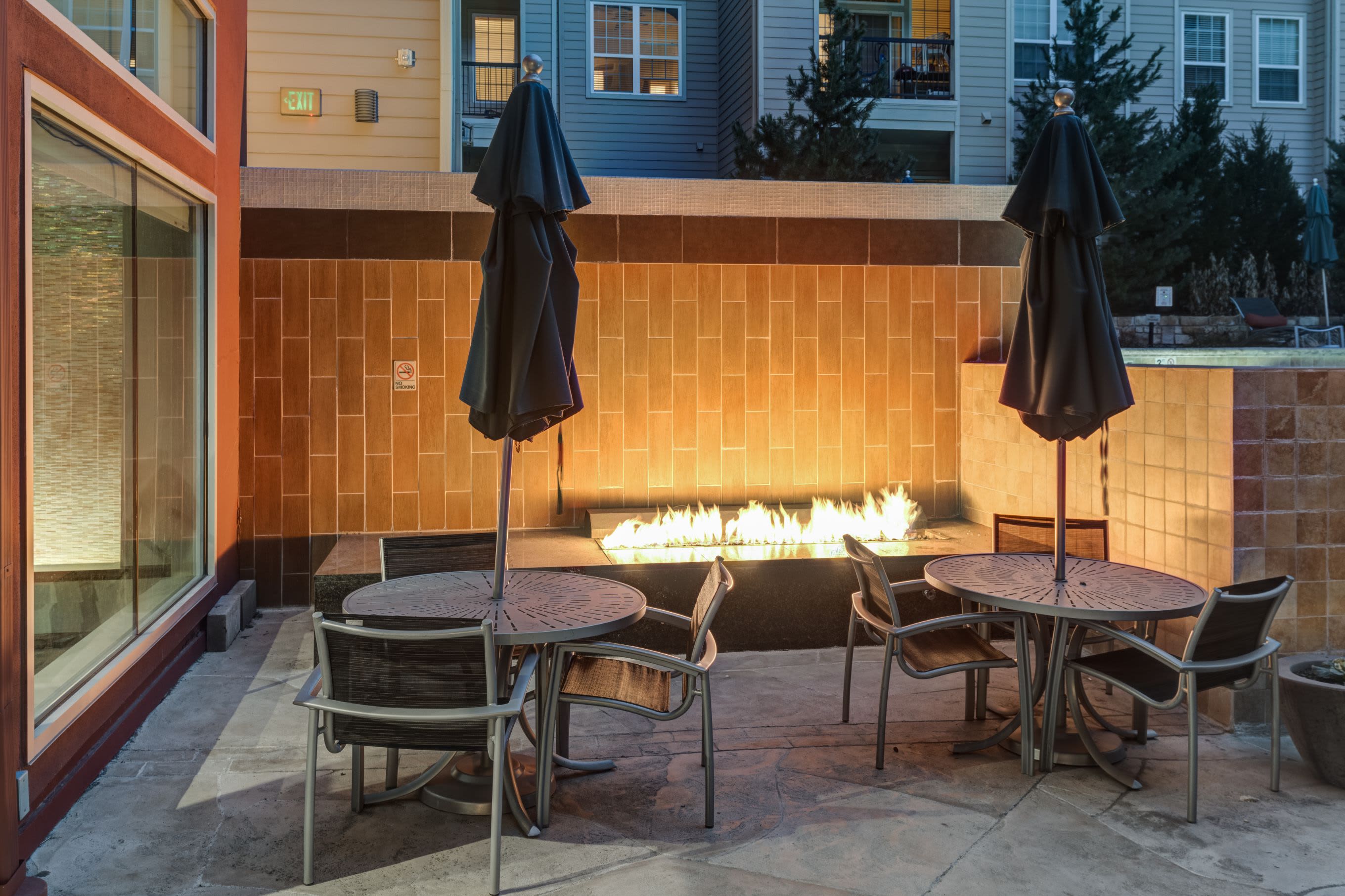 Table and chairs with a gas fire pit outside at The Marq at Ridgegate in Lone Tree, Colorado