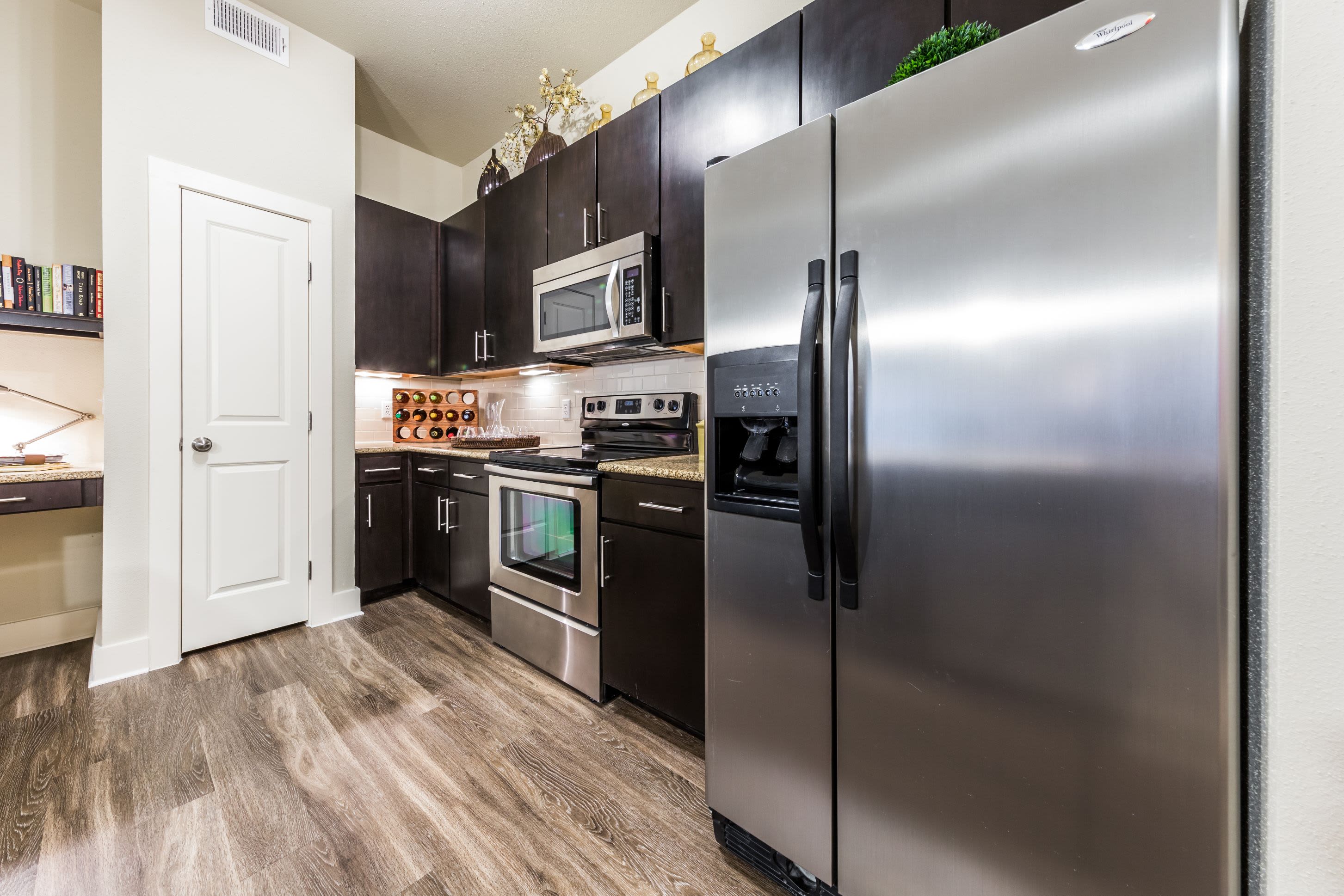 Stainless steel appliances and dark cabinets in kitchen at The Marq at Ridgegate in Lone Tree, Colorado