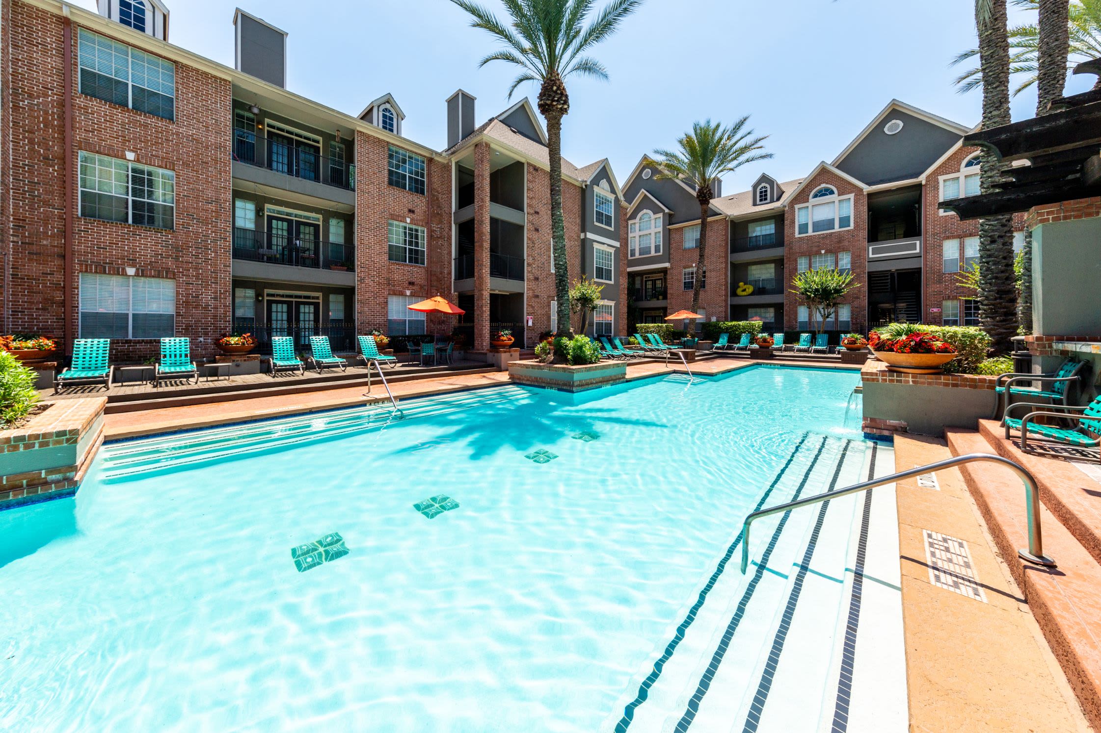 Sparkling pool with lounge chairs on deck at Marquis on Pin Oak in Houston, Texas