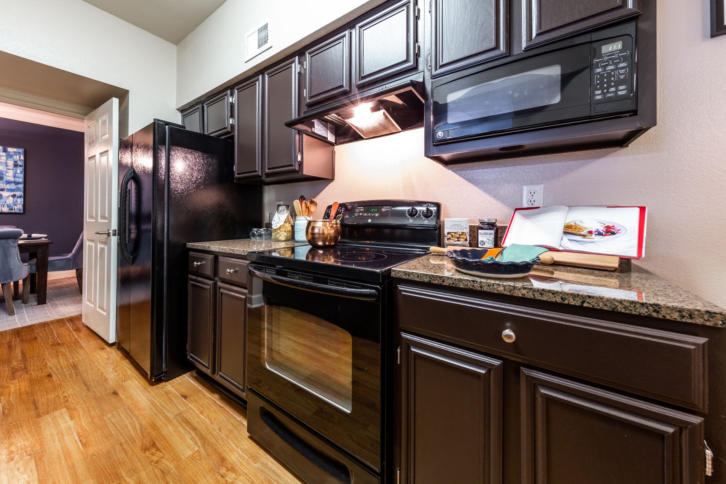 Kitchen with mocha colored cabinets at Marquis on Pin Oak in Houston, Texas