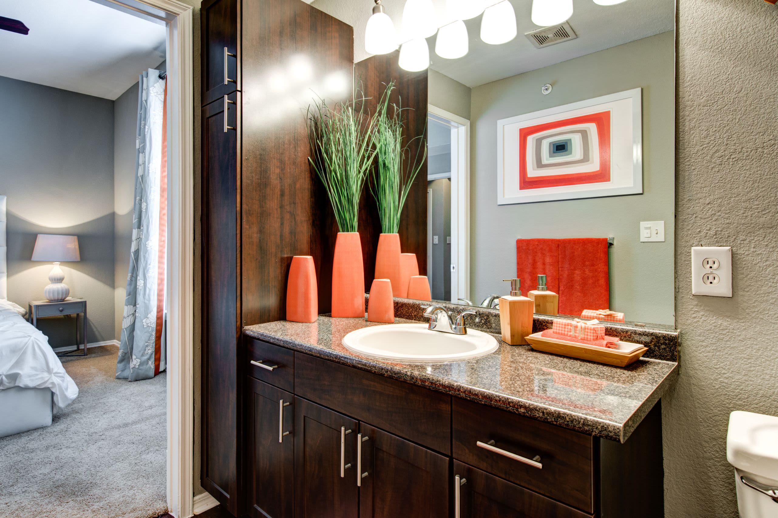 Bathroom with a large mirror and dark brown cabinets at Marquis on Gaston in Dallas, Texas