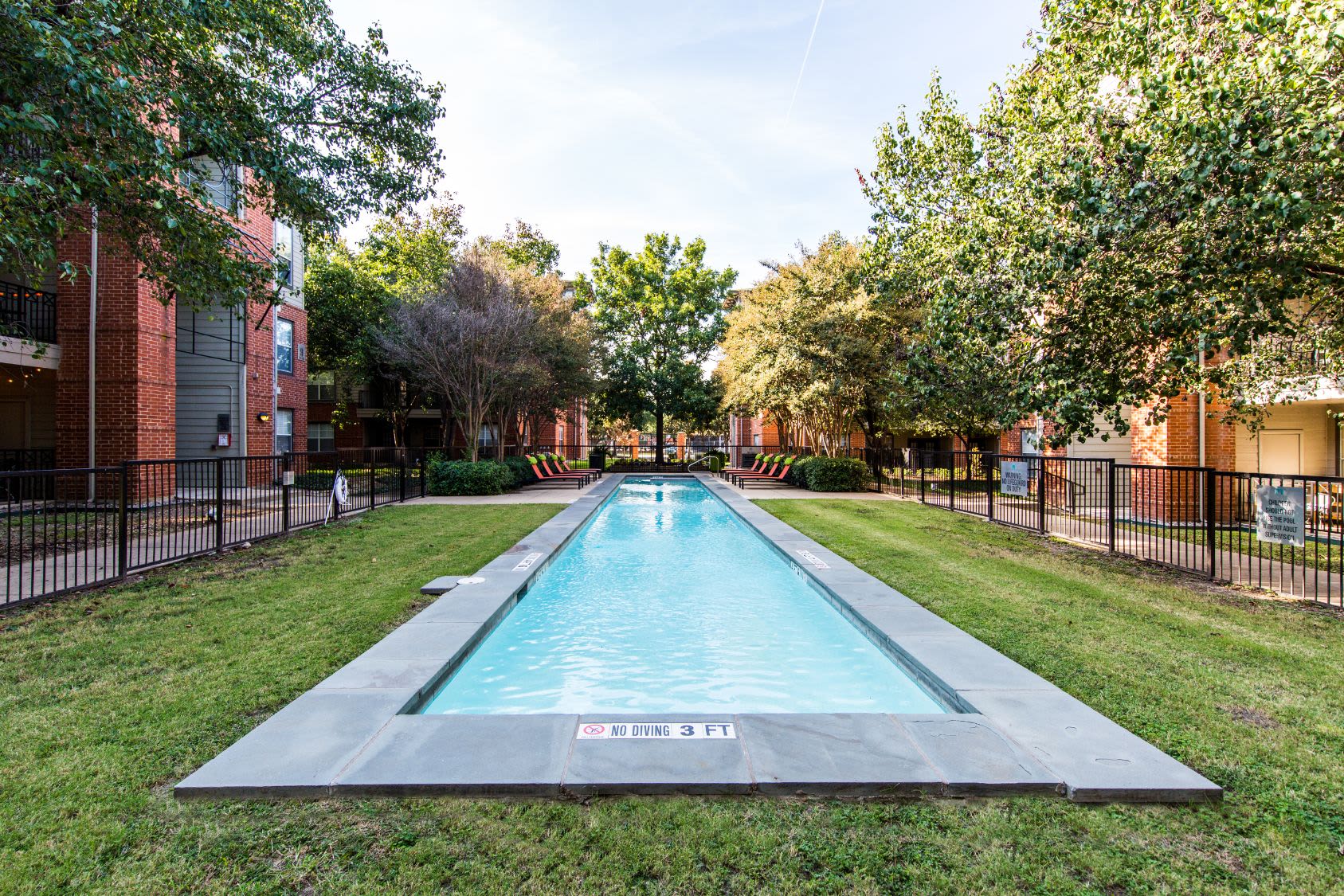Long and skinny swimming pool surrounded by grass at Marquis on Gaston in Dallas, Texas