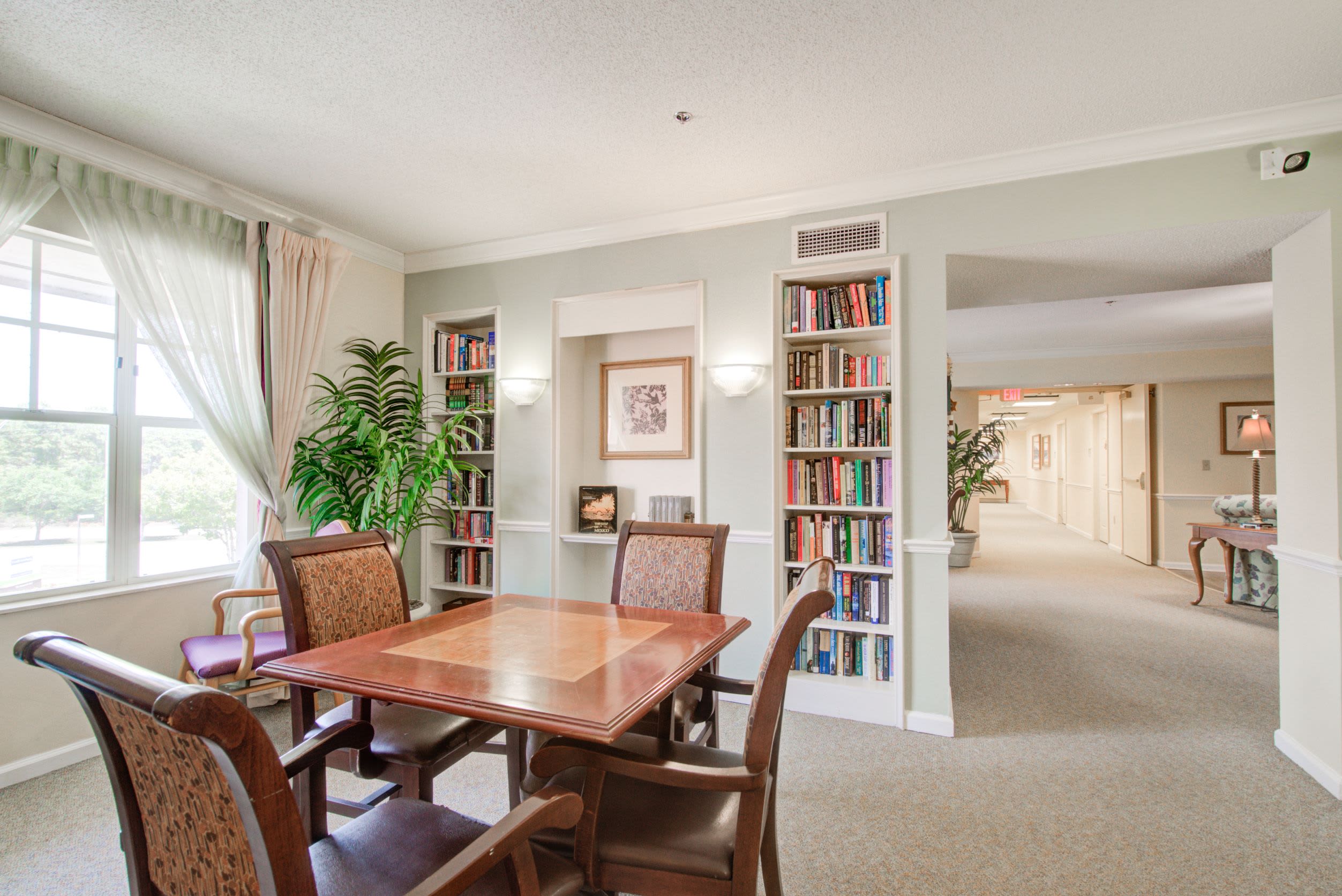 A library with a small table and chairs at Truewood by Merrill, Venice in Venice, Florida