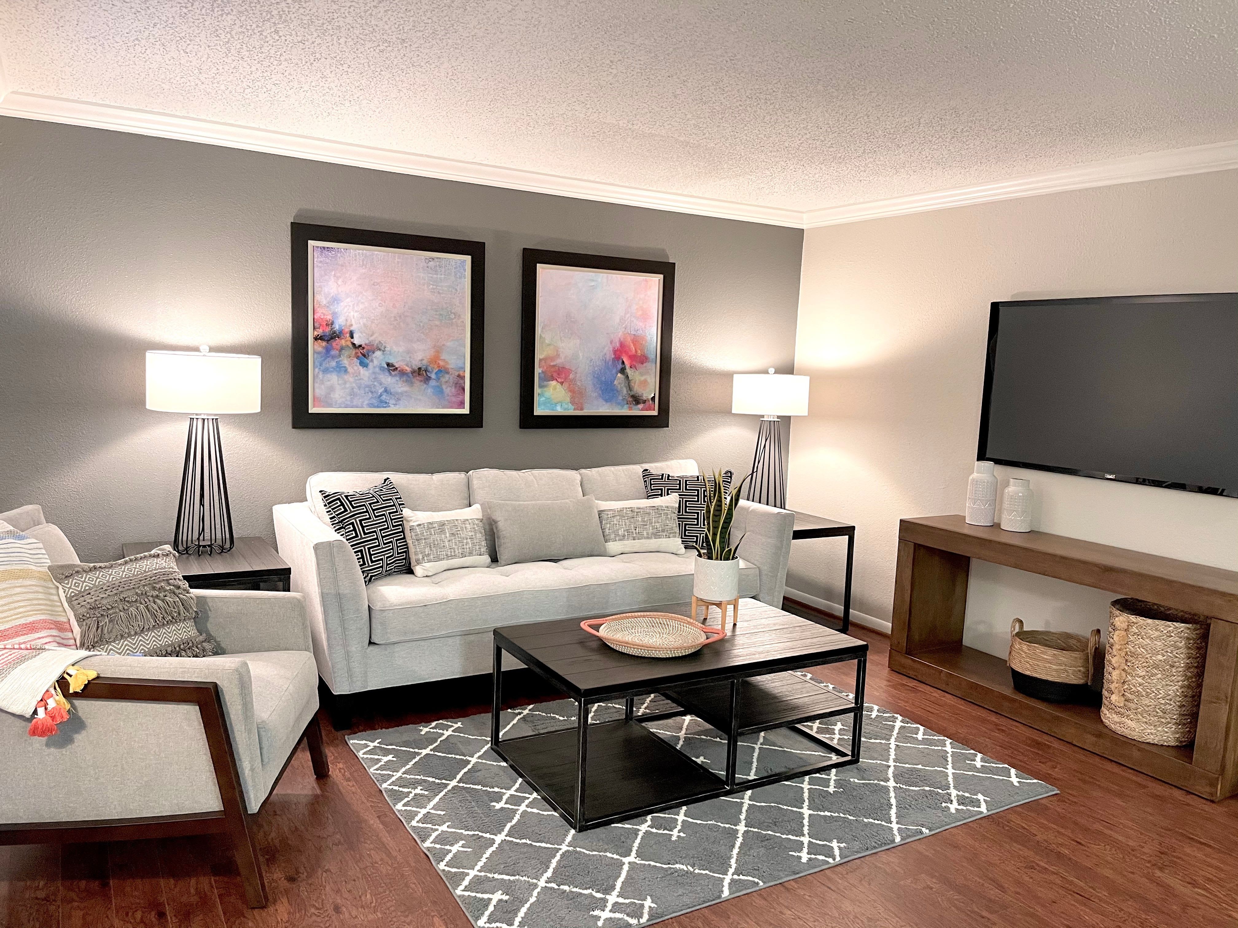 Spacious living room with stylish finishes and wood-inspired flooring at The Abbey at Briargrove Park in Houston, Texas