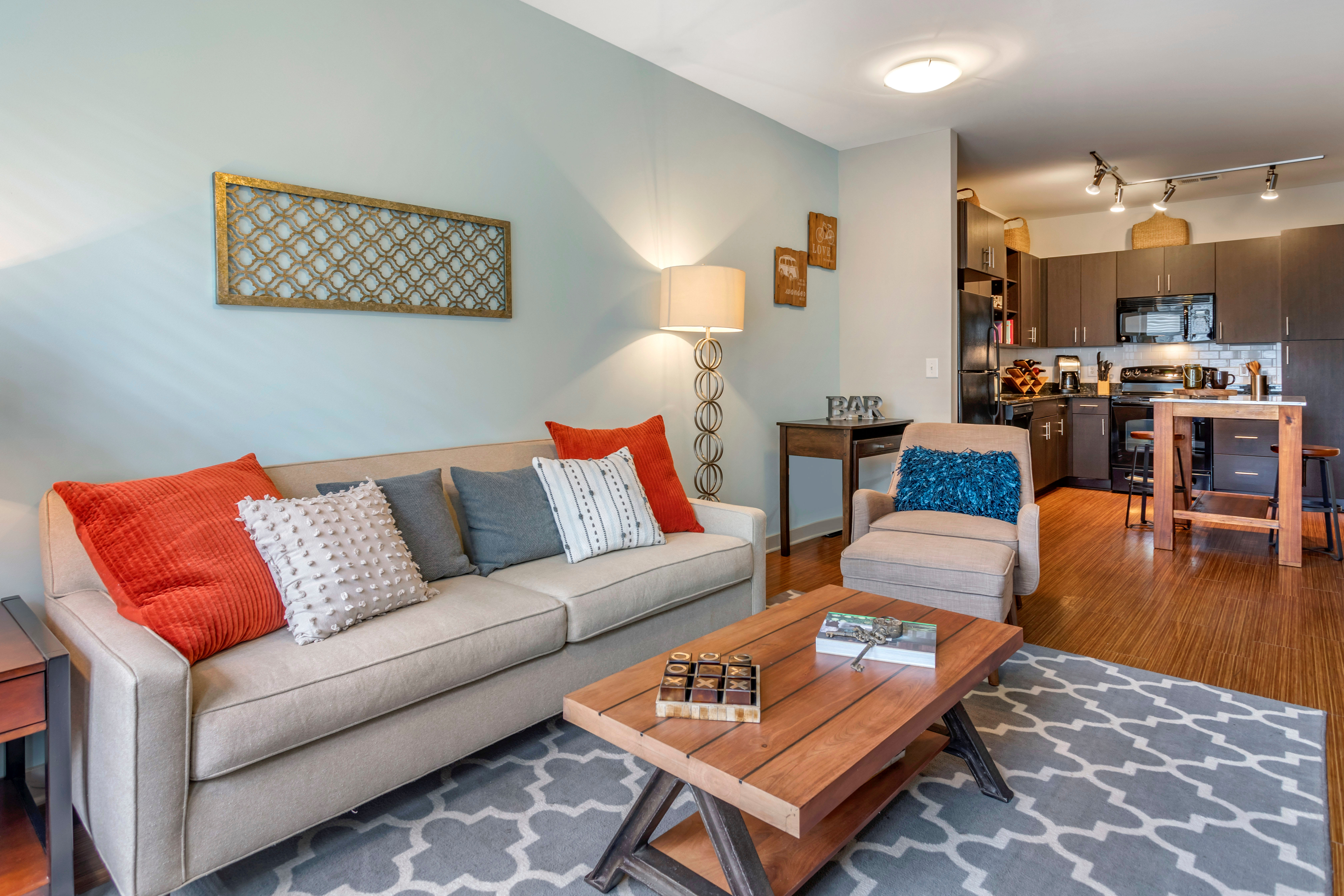 Accent wall and hardwood flooring in a model home's living area at Olympus Midtown in Nashville, Tennessee