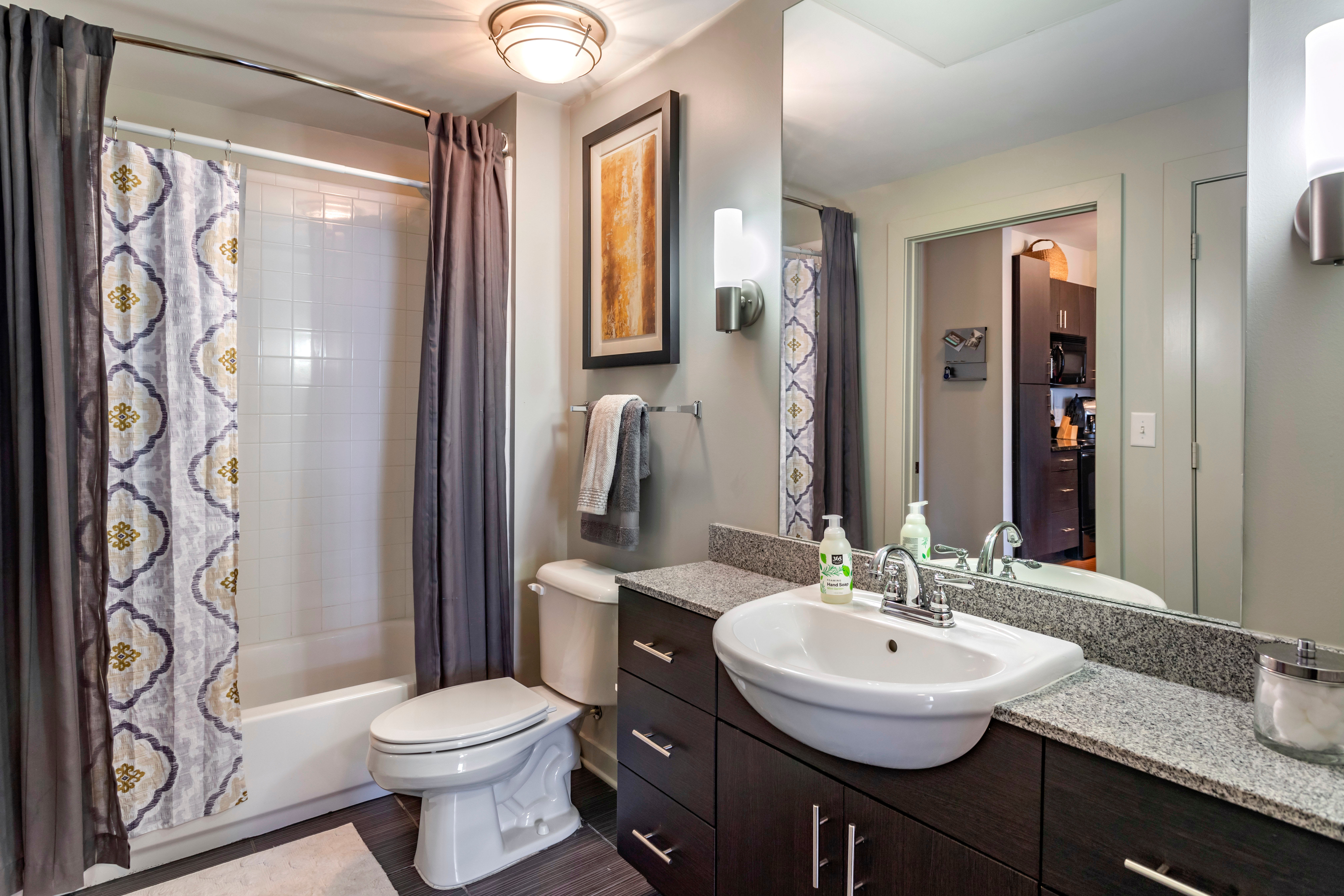 Spacious primary bathroom with extra storage in a model apartment at Olympus Midtown in Nashville, Tennessee