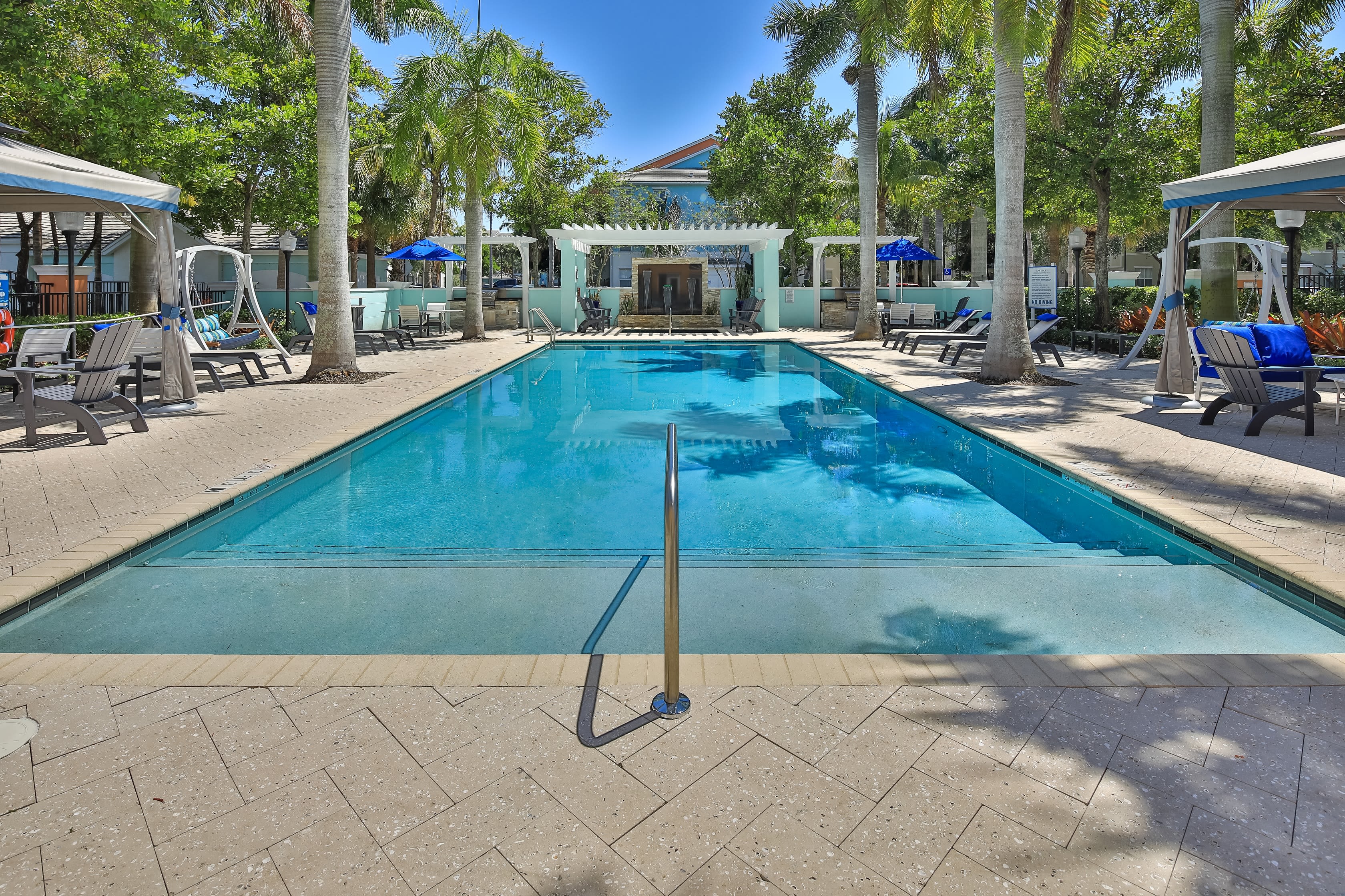 Resort style swimming pool surrounded by palm trees at The Pearl in Ft Lauderdale, Florida