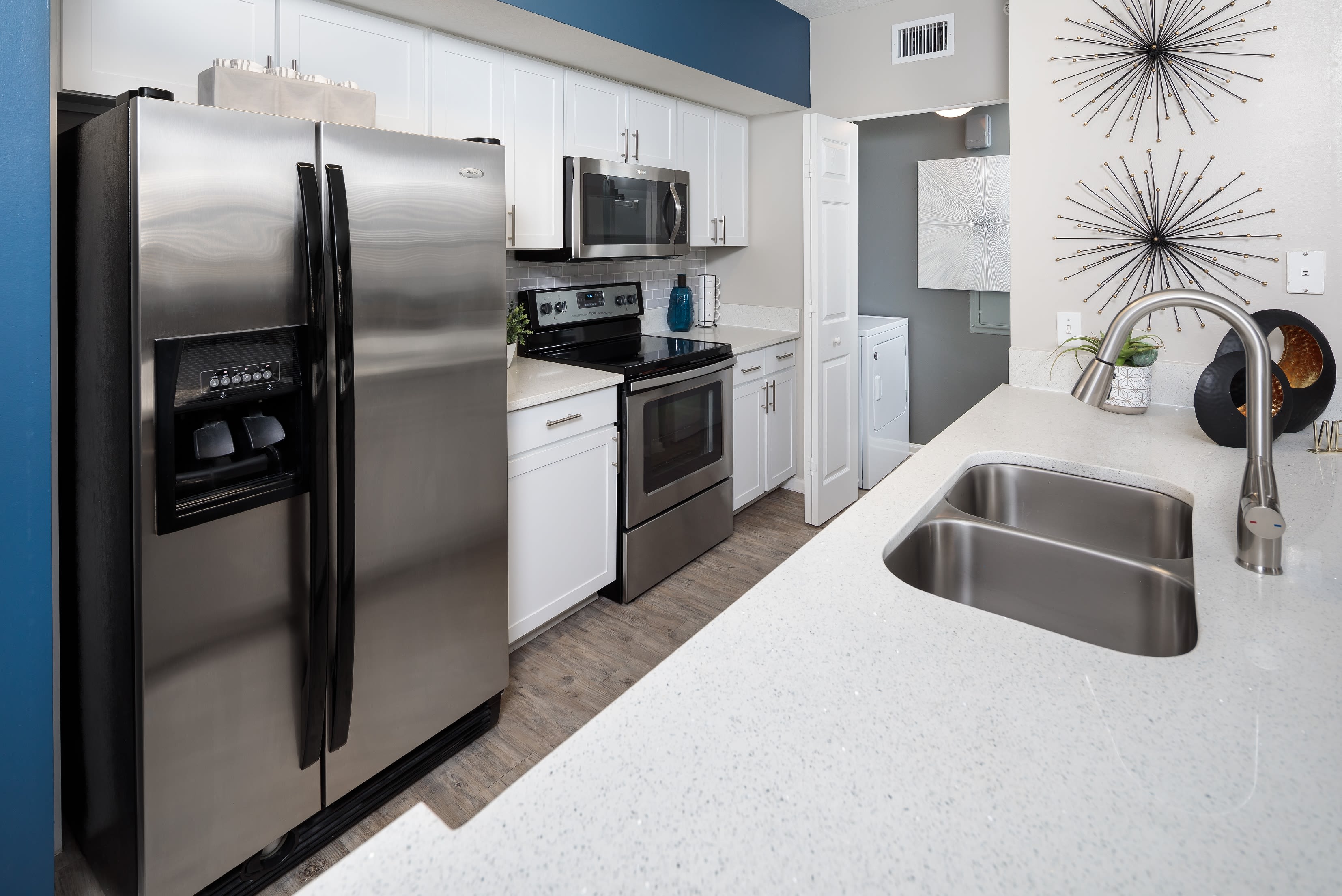 Kitchen area with sleek white cabinets and stainless steel appliances at The Pearl in Ft Lauderdale, Florida