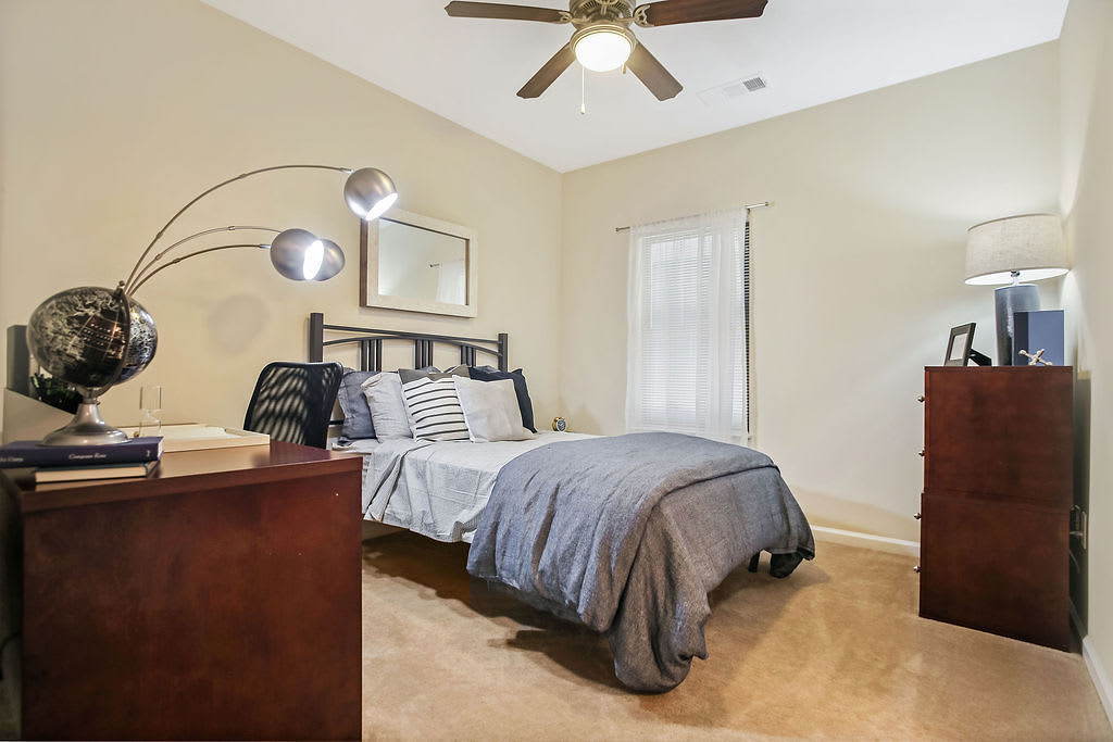 Model student bedroom with plush carpeting and a ceiling fan at West 22 in Kennesaw, Georgia