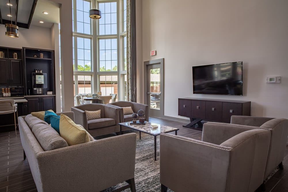 lounge area with a tv and several plush chairs arranged around a coffee table at The Spring at Silverton in Fort Worth, Texas