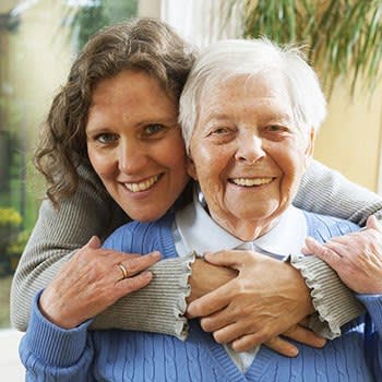 <p>Daughter hugging her mother and both smiling for a photo at Arcadia Senior Living Pace in Pace, Florida</p>