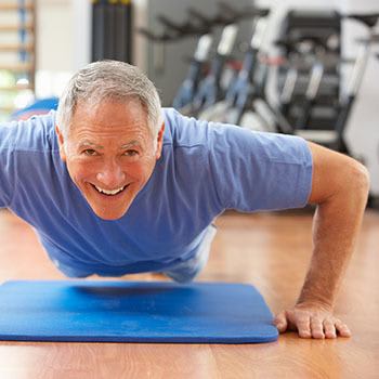 <p>Smiling resident doing some pushups in a fitness class at Arcadia Senior Living Pace in Pace, Florida</p>