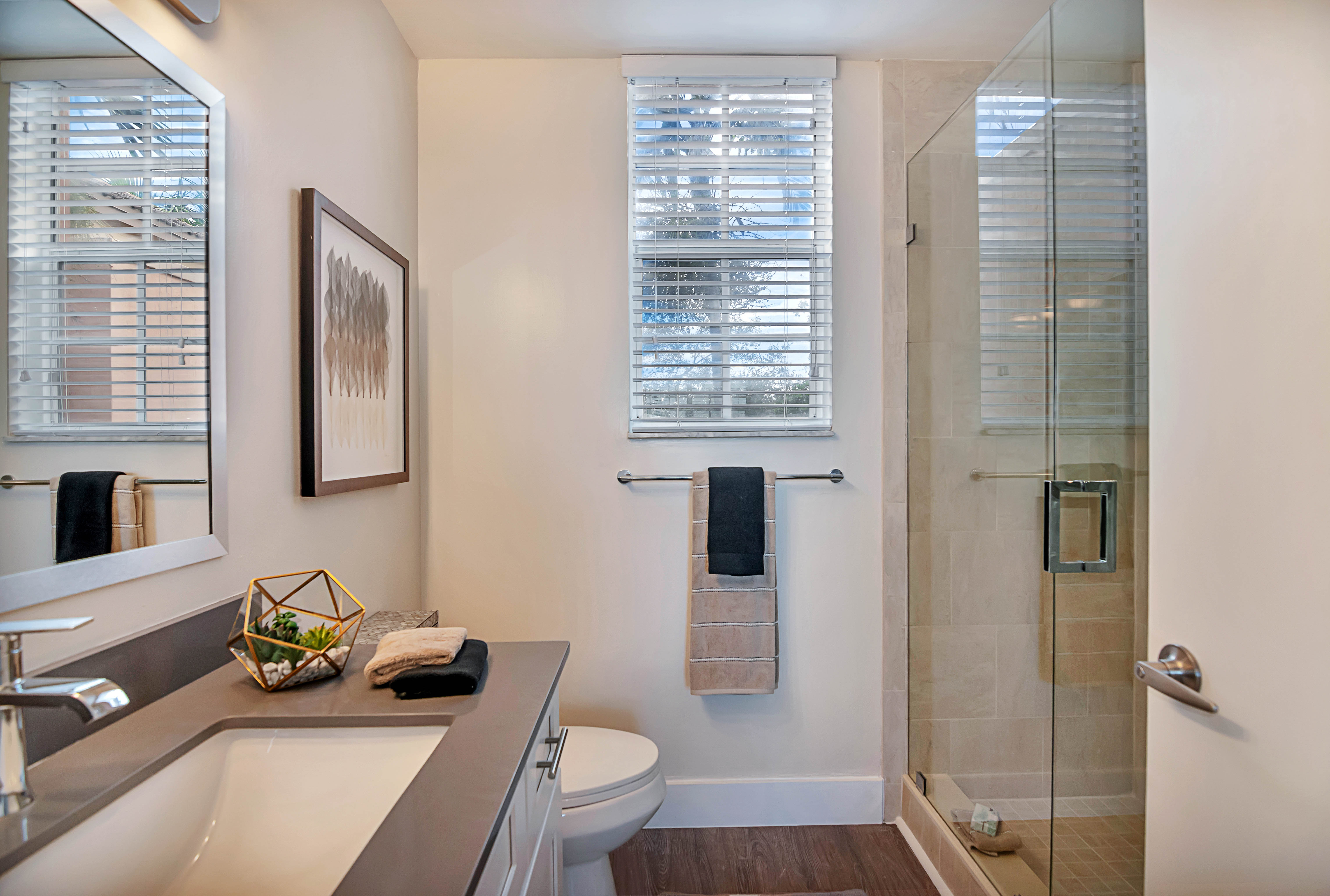 Model bathroom with glass shower door at St. Tropez Apartments in Miami Lakes, Florida
