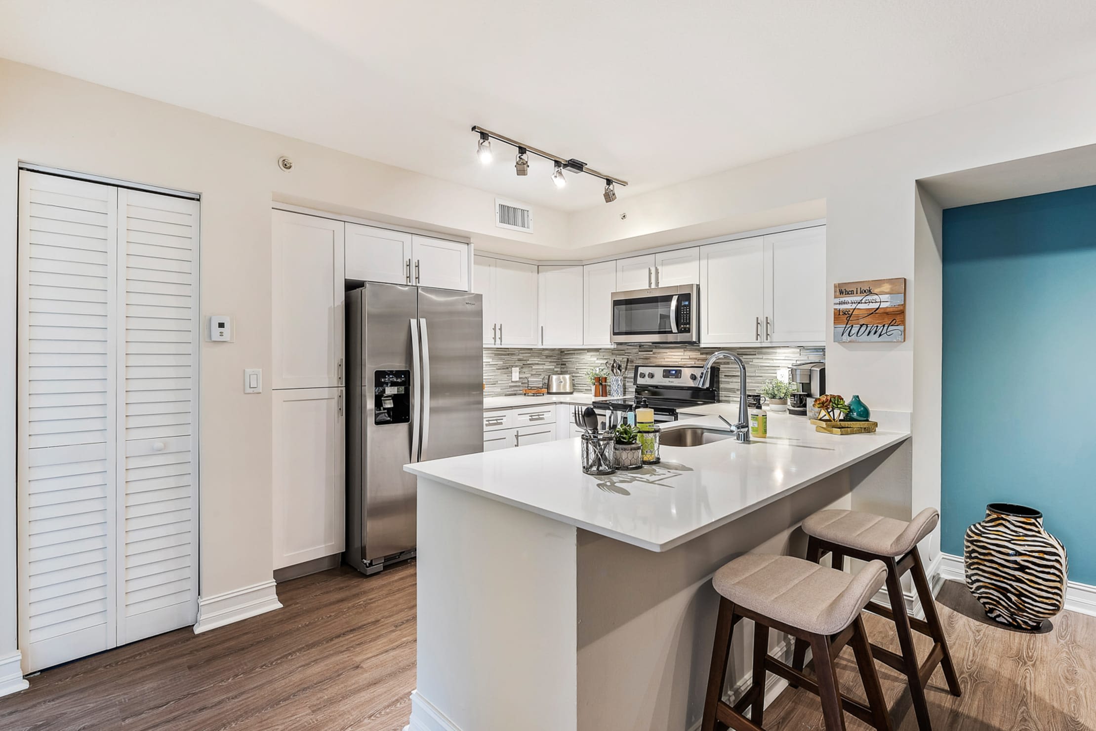 Beautiful model kitchen with counter seating at Crescent House Apartments in Miami Lakes, Florida