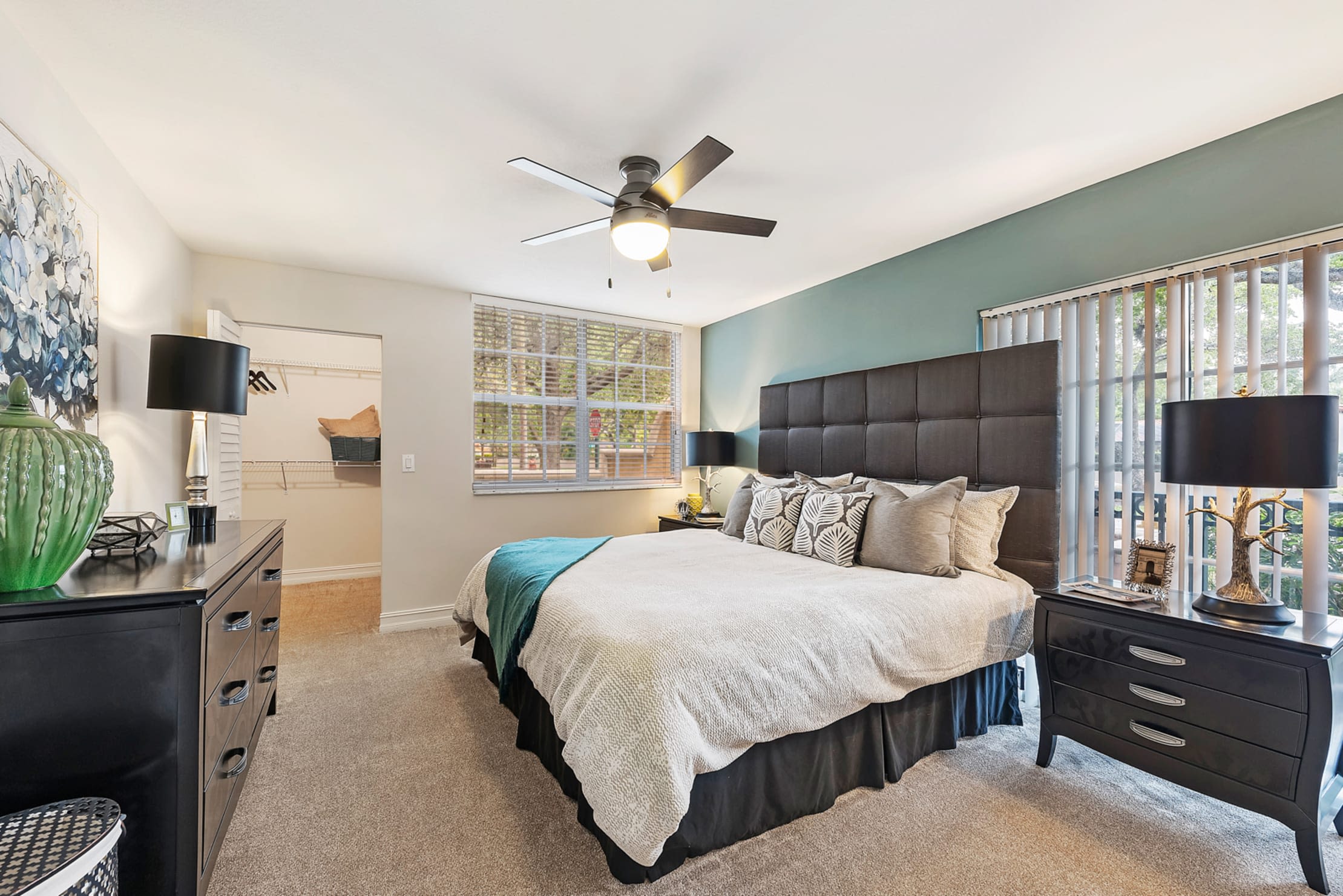 Model bedroom with ceiling fan and a walk-in closet at Crescent House Apartments in Miami Lakes, Florida