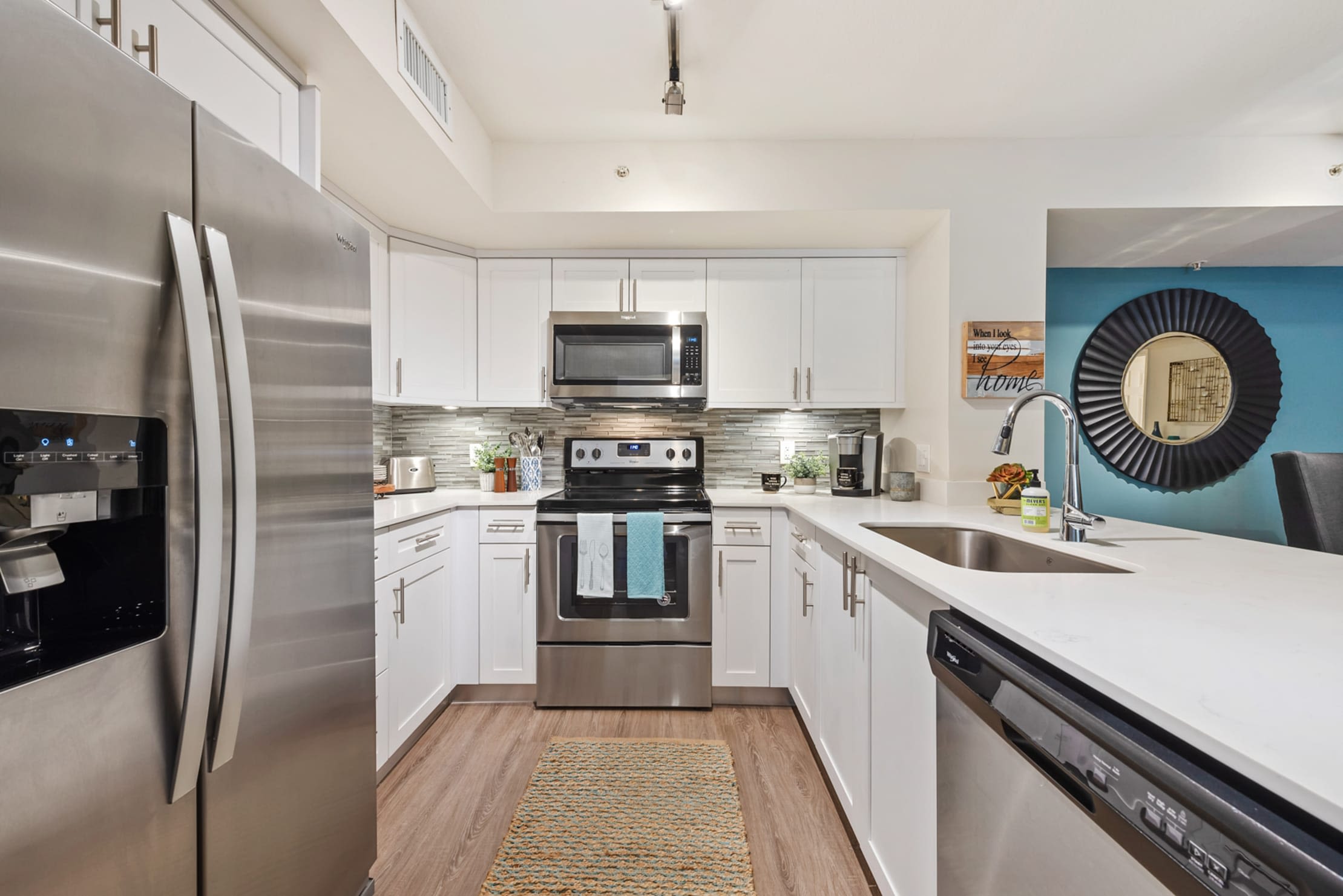 Model kitchen with stainless steel appliances and expansive counter space at Crescent House Apartments in Miami Lakes, Florida