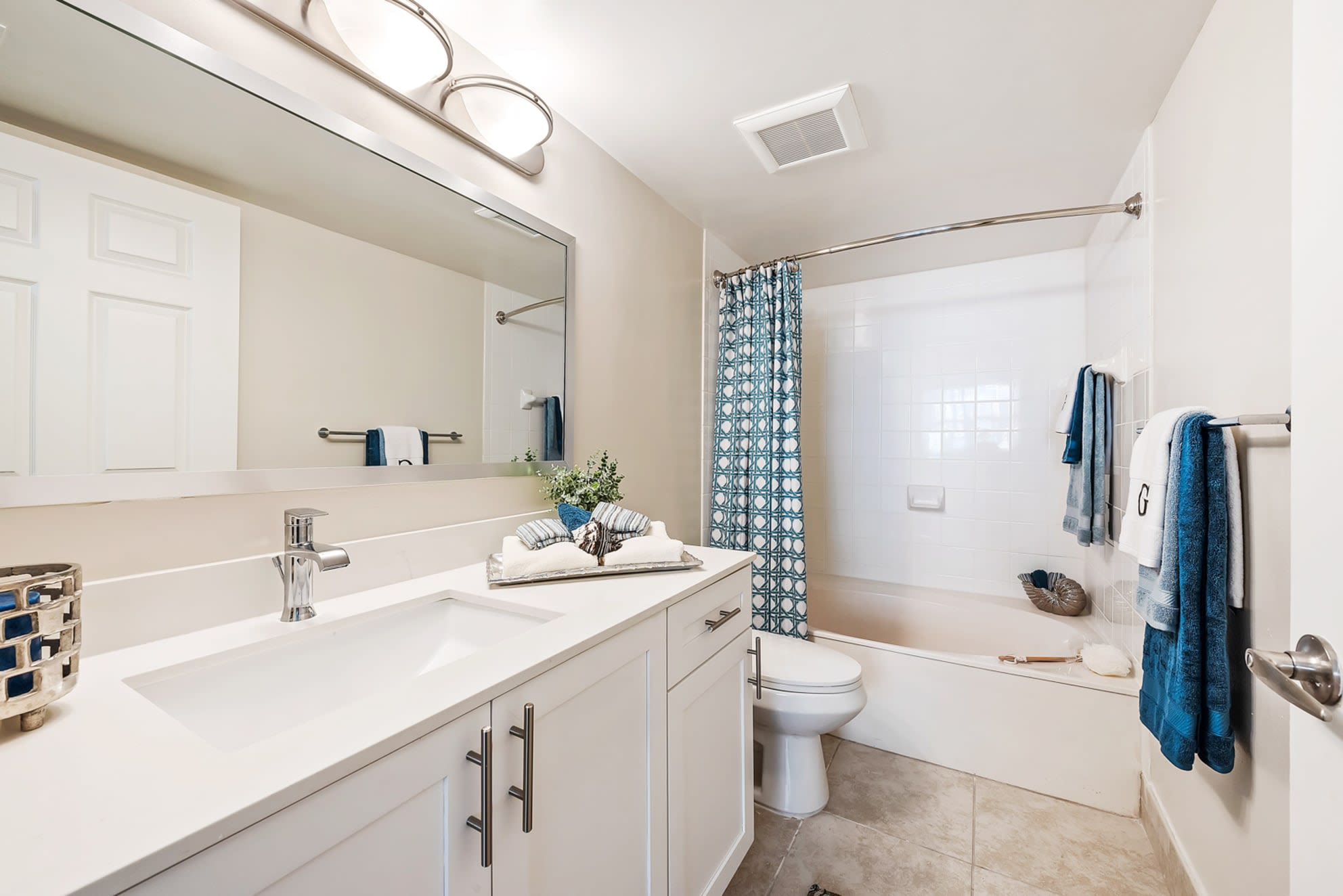 Model bathroom with spacious cabinet storage at Crescent House Apartments in Miami Lakes, Florida