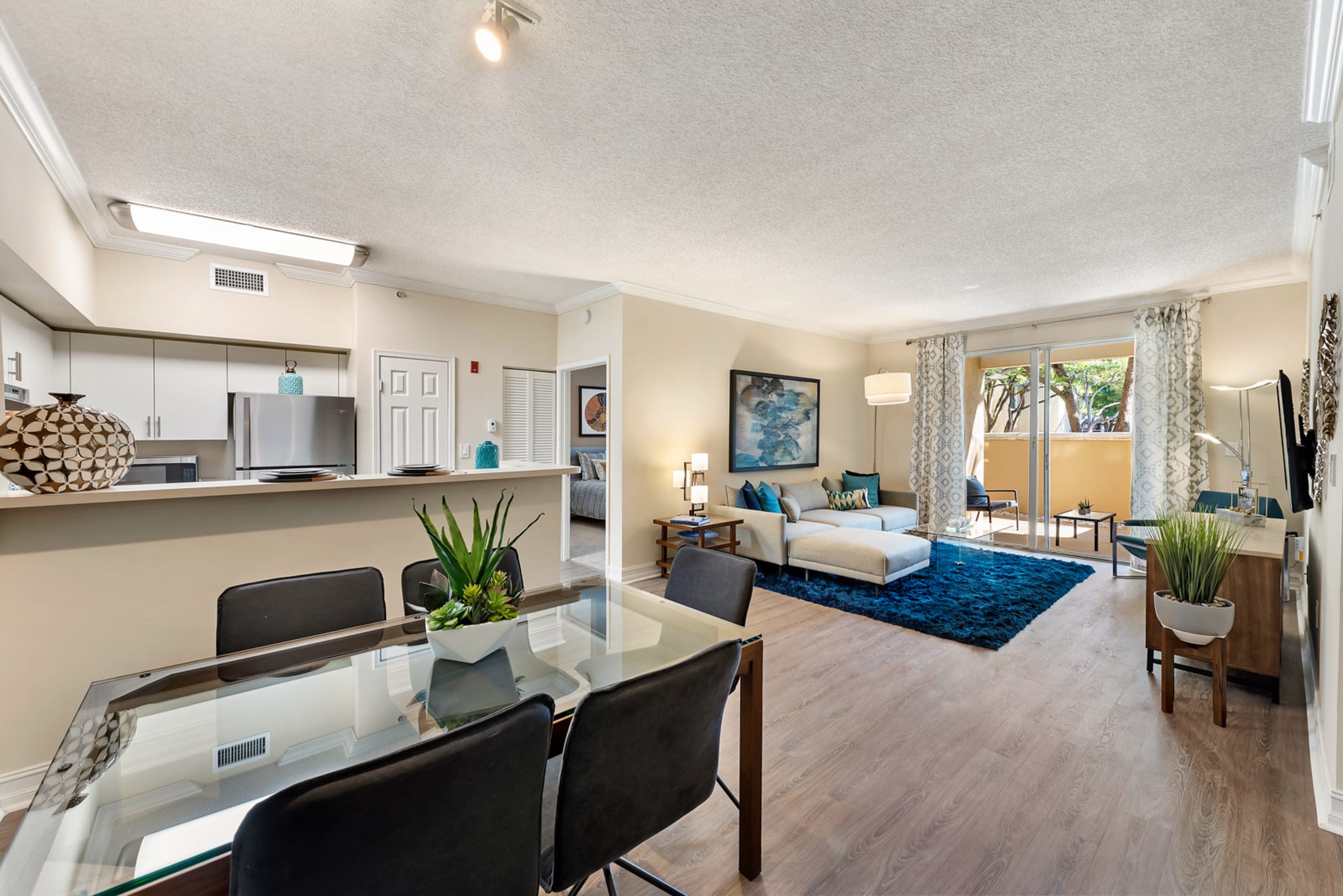 Open and spacious living room with connected private patio space at Fountain House Apartments in Miami Lakes, Florida