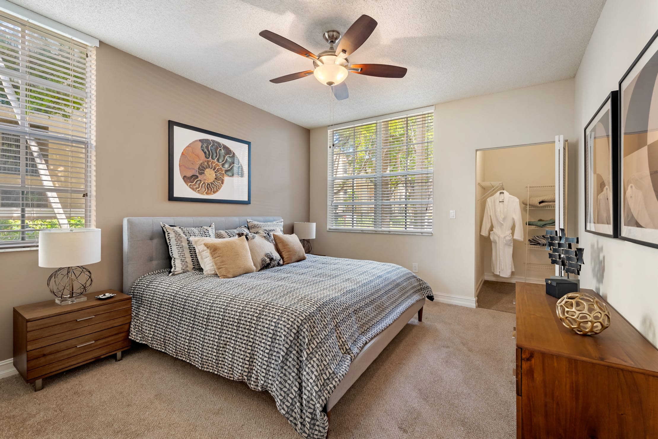 Beautiful model bedroom with a ceiling fan and plush carpeting at Fountain House Apartments in Miami Lakes, Florida